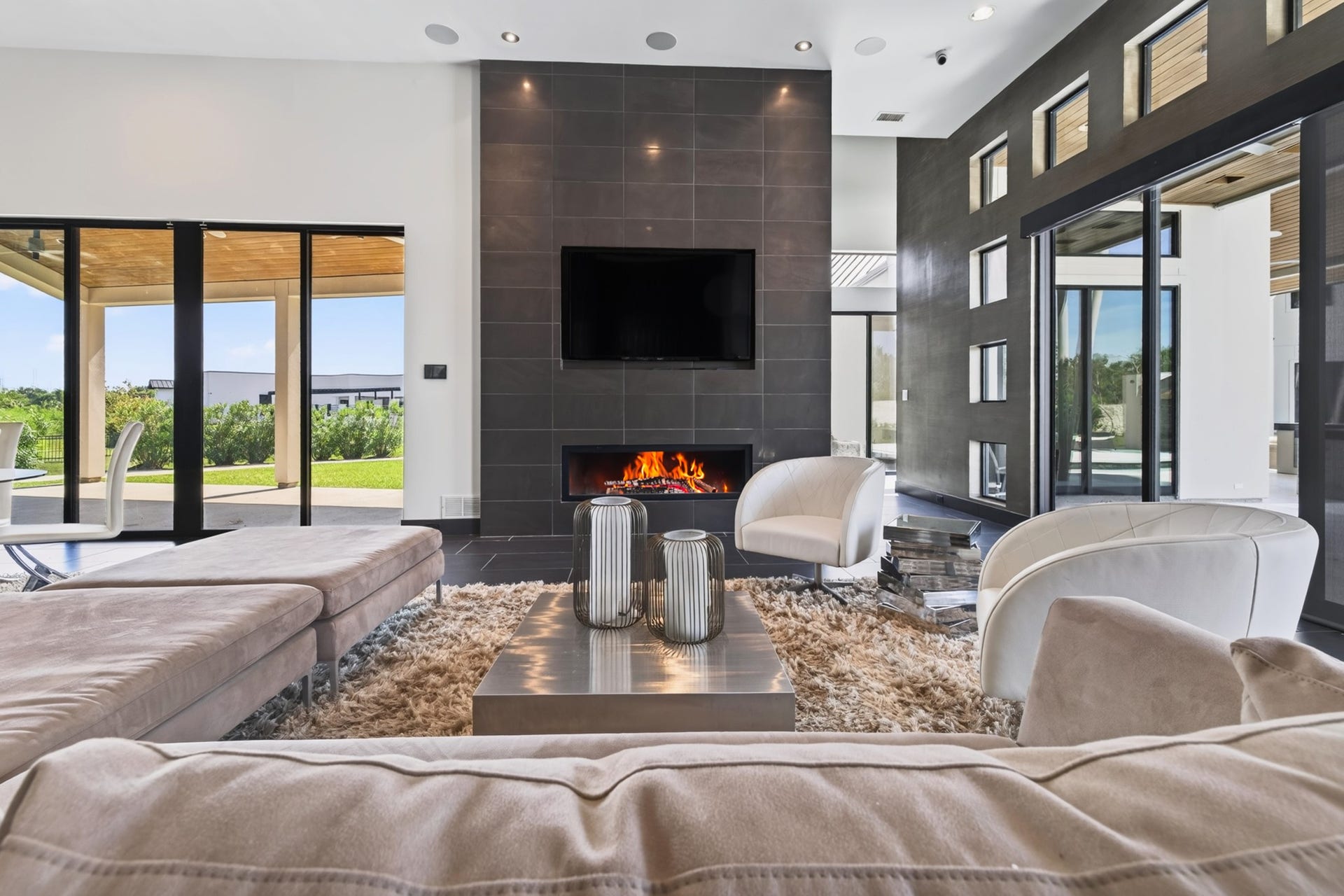 Additional living space features a fireplace, expansive windows and seamless access to the outdoors.