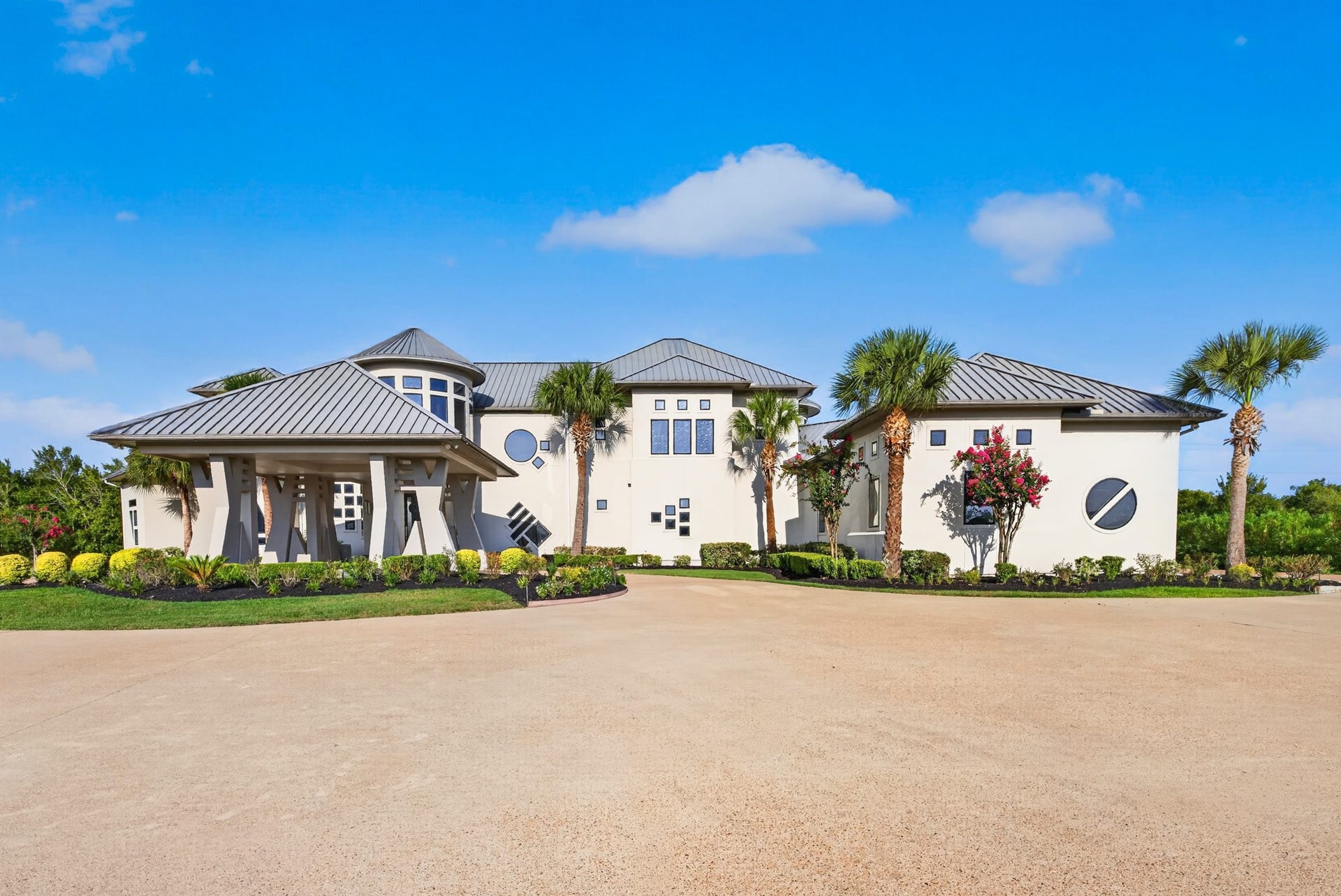 Grand approach highlights the homes striking contemporary architecture and manicured setting.