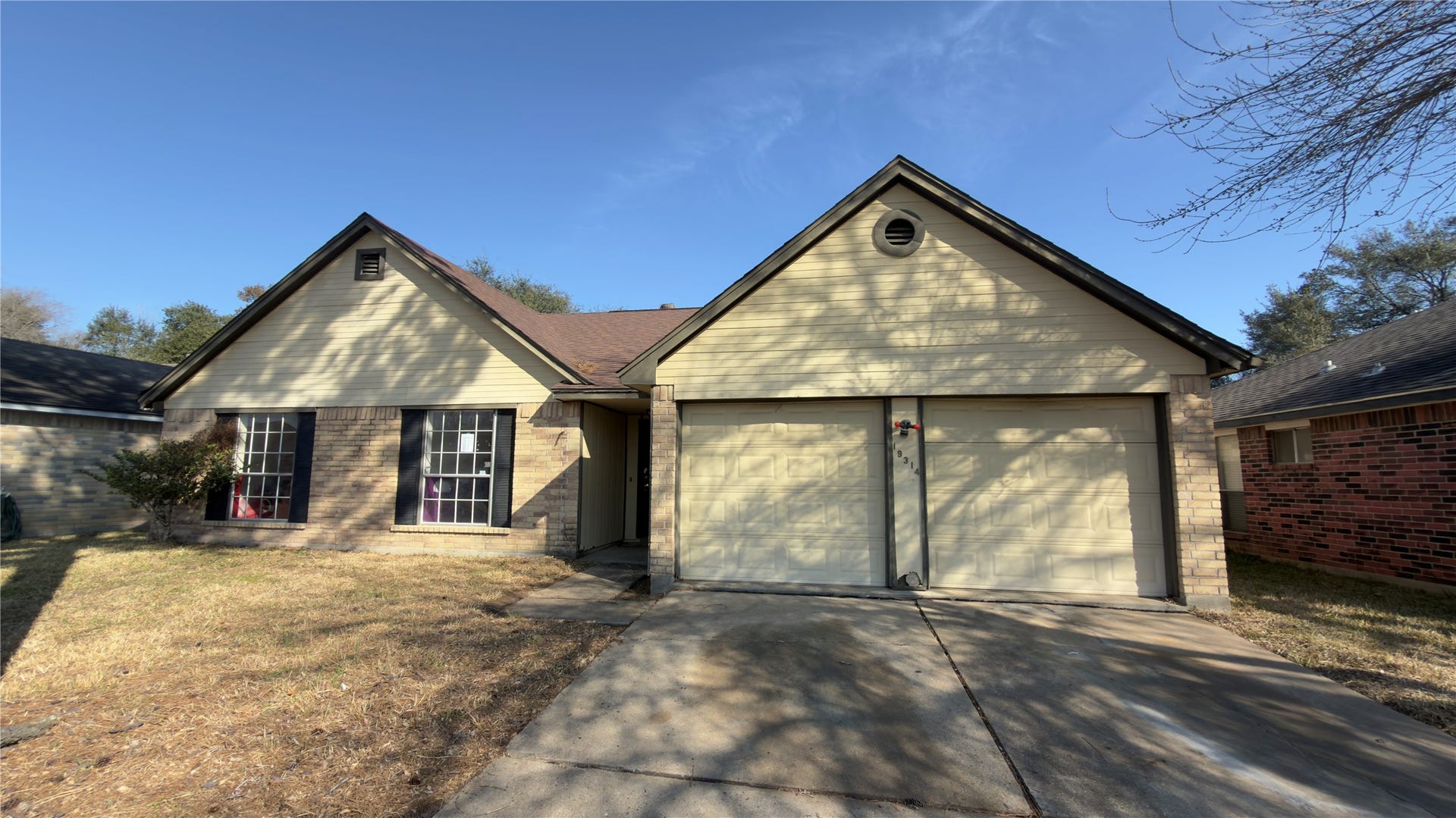 19314 Indian Grass Drive, Katy, TX 77449 Charming single-story home featuring a dual-gabled roof, spacious driveway, and a two-car garage. The exterior is accented with brick and large windows, offering a welcoming curb appeal.