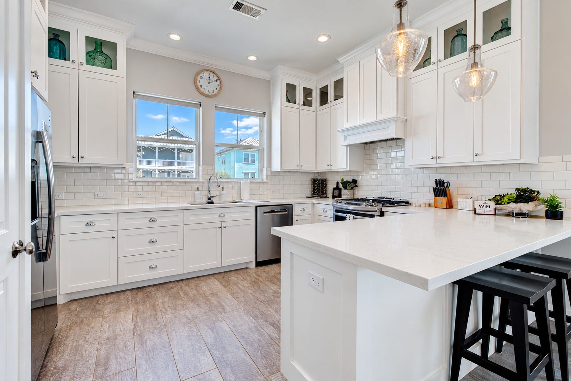 3802 Abalone Road, Galveston, TX 77554 The kitchen with shaker cabinets, quartz countertops, classic subway tile backsplash, and breakfast bar with pendant lighting.