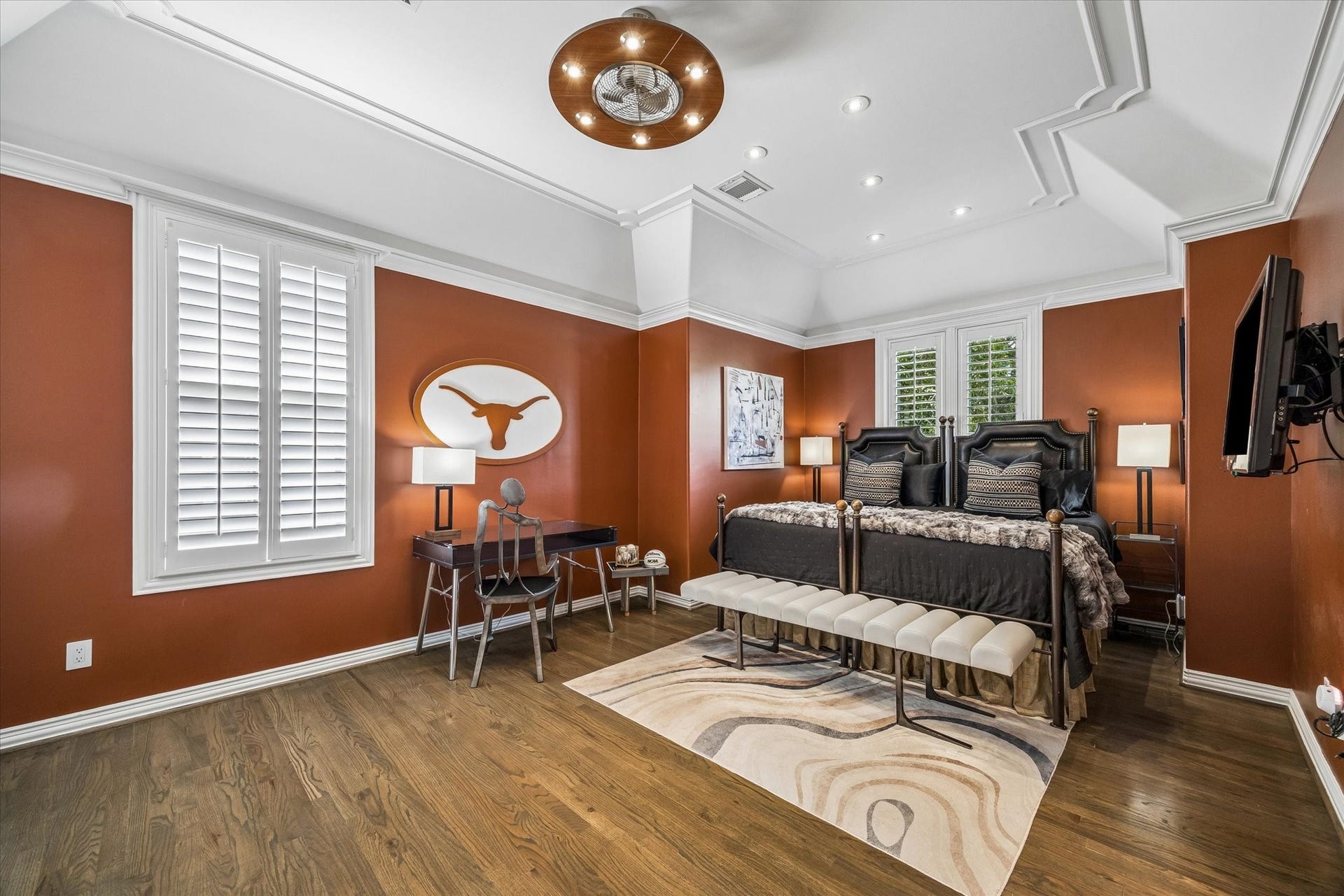 This generously sized secondary bedroom has plantation shutters, a detailed tray ceiling, and access to the shared bathroom.