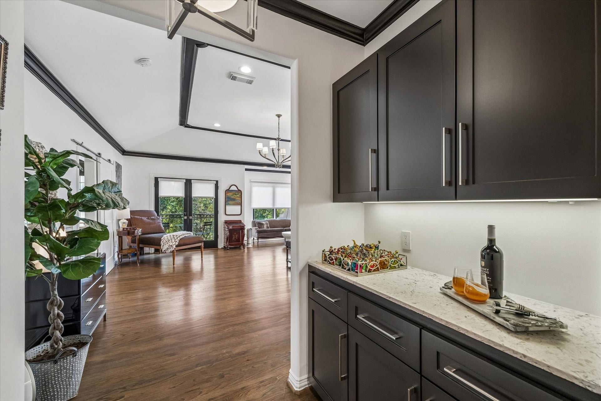 The entrance to the primary suite features custom cabinetry with Carrera quartzite countertops.