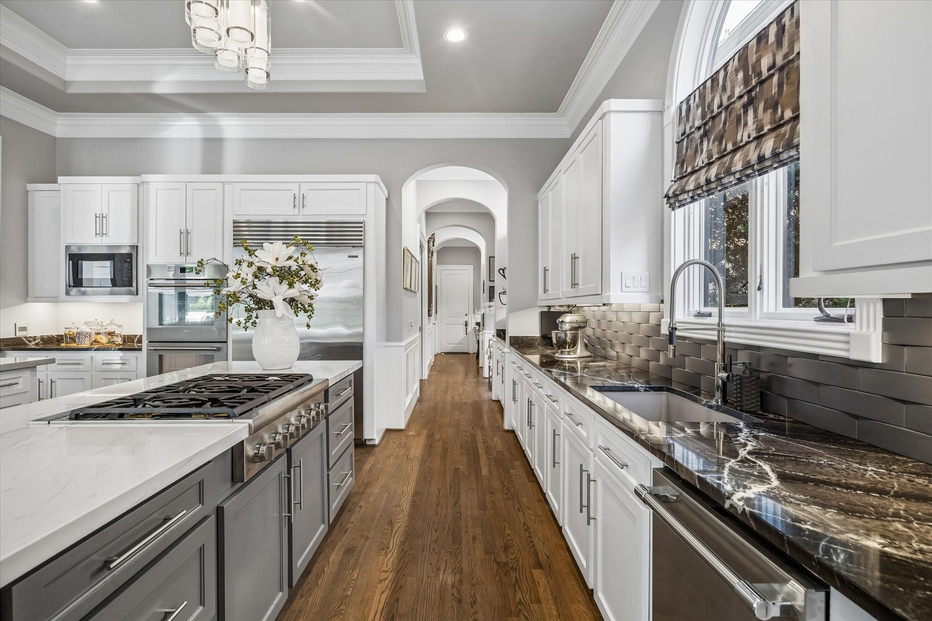 Appliances include a Thermador 6-burner gas cooktop, double ovens, and dishwasher, along with a Sub-Zero refrigerator.