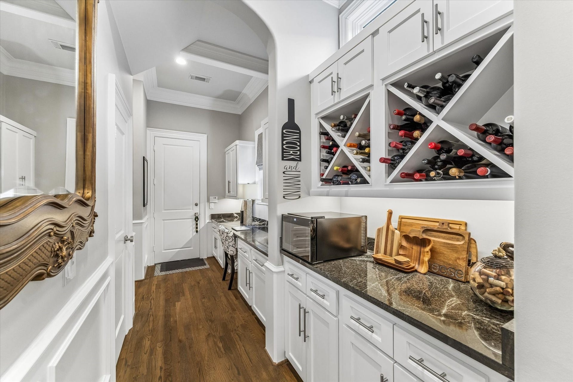 This well-appointed butler's pantry features diamond-bin wine storage, Tempesta granite countertops, and a built-in desk area.