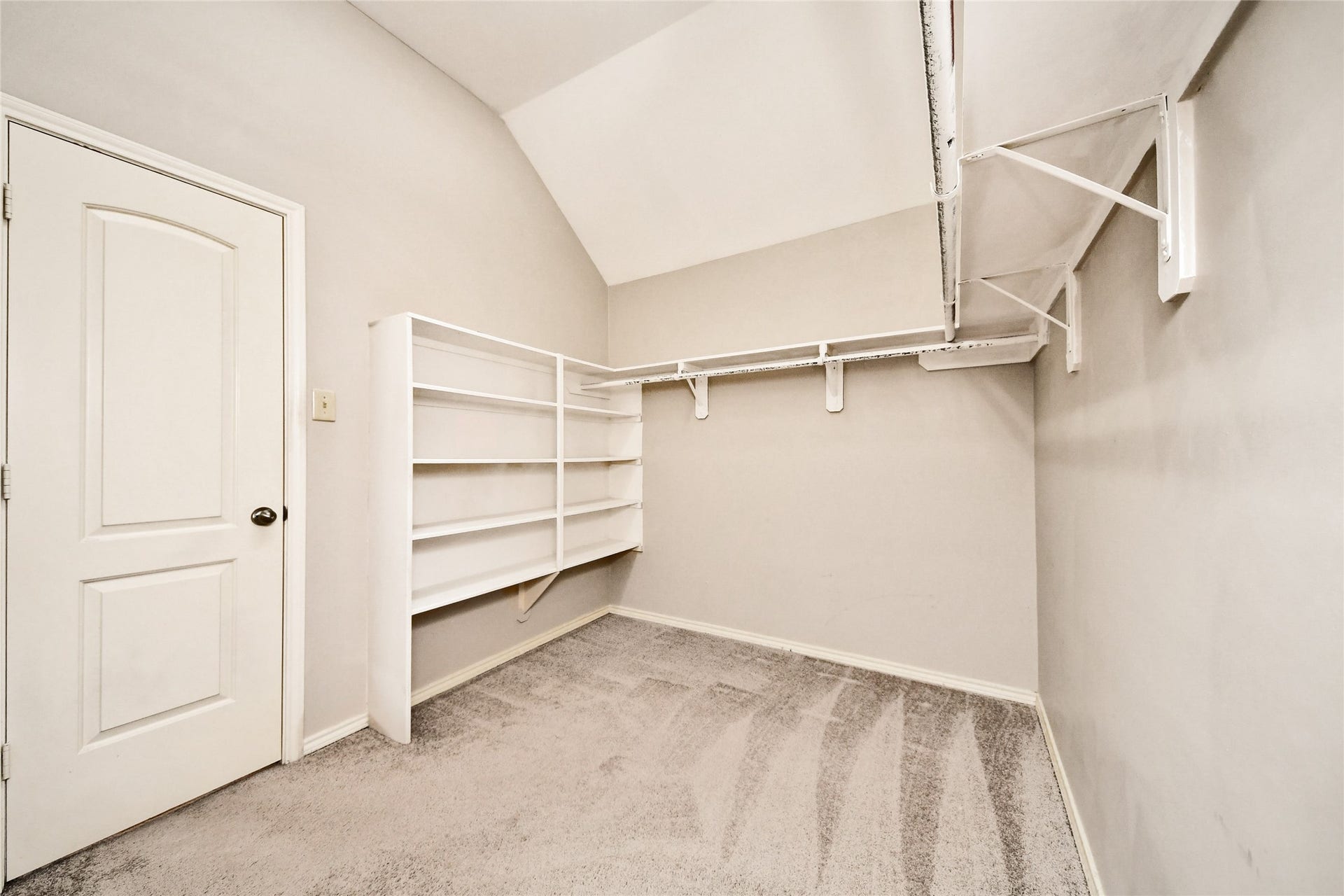 Spacious walk-in closet featuring ample shelving and hanging space, perfect for organized storage.