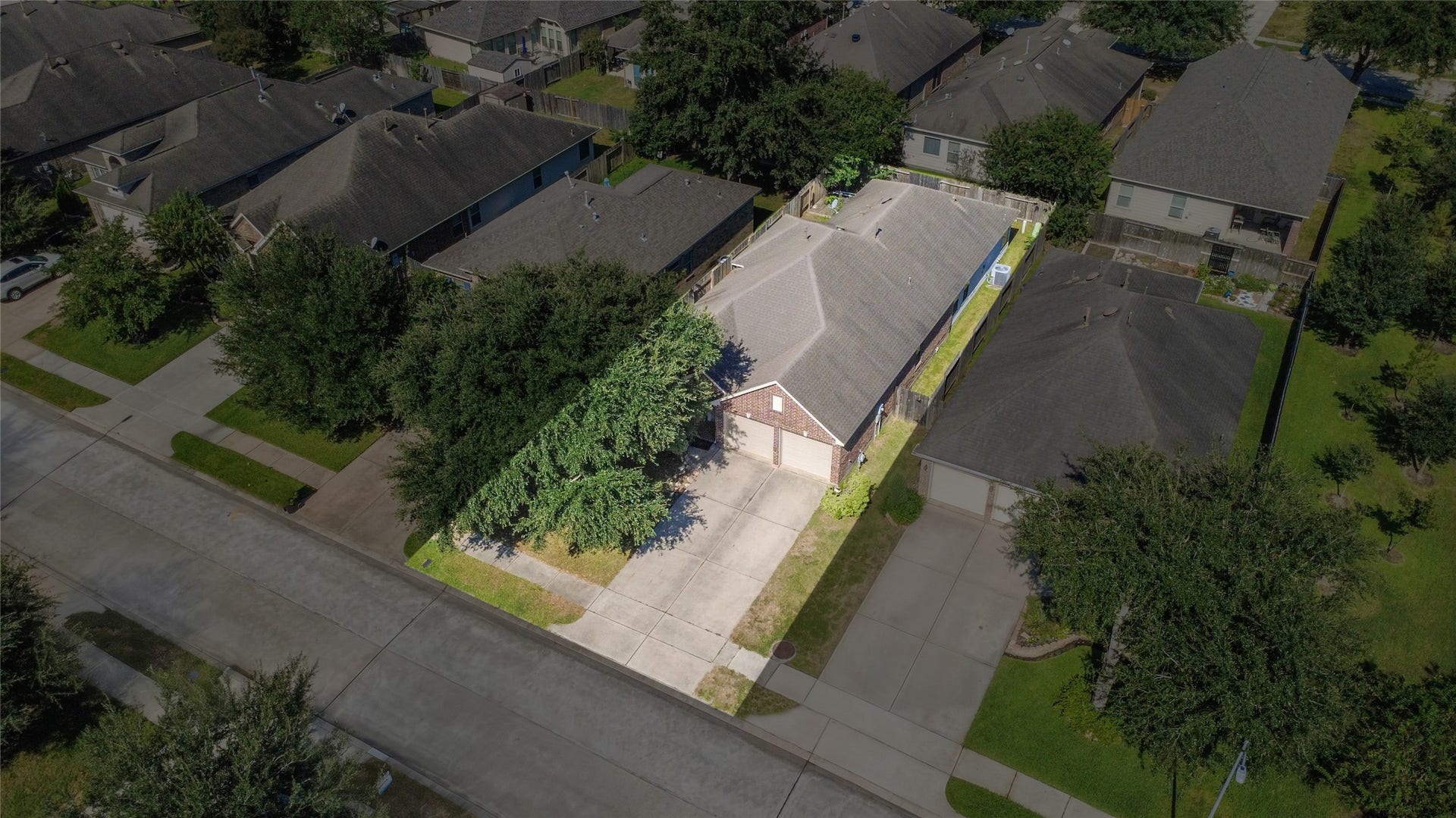 Charming single-story home nestled in a quiet neighborhood, featuring a spacious driveway and lush greenery for added privacy.