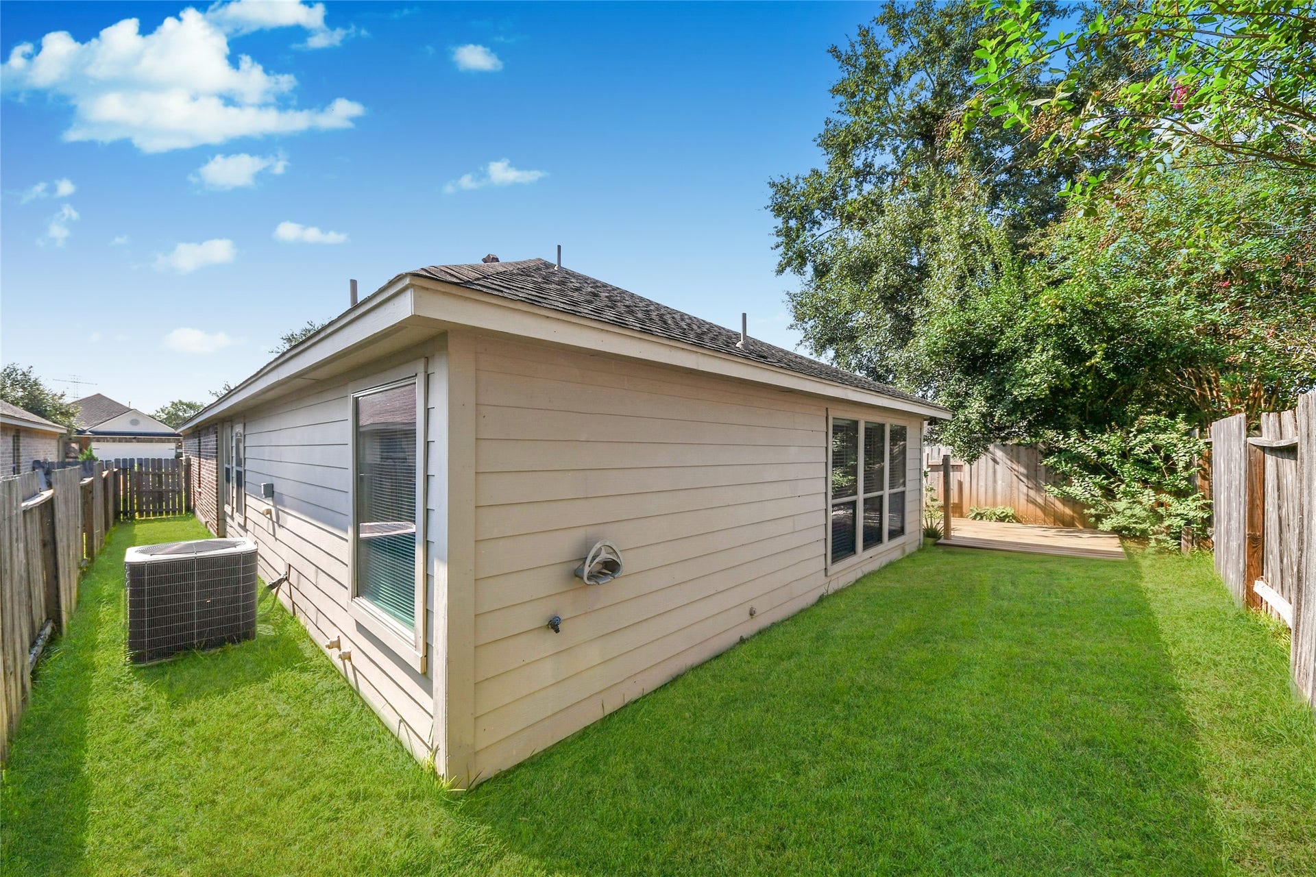 Charming backyard with lush green lawn and a cozy deck, perfect for outdoor relaxation and entertaining.