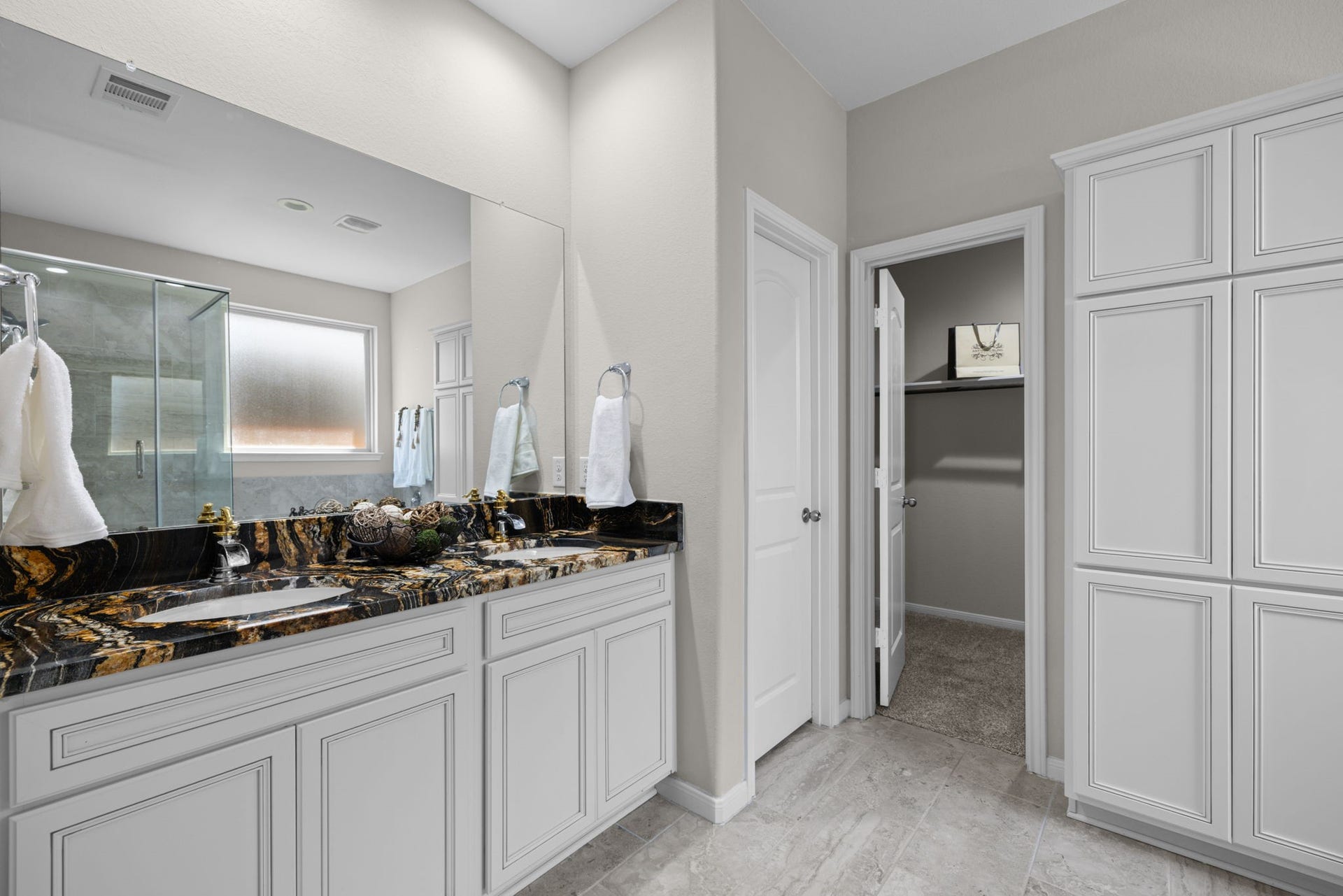 25615 Pinyon Hill Trail, Tomball, TX 77375 The ensuite bath has high vanity with double sinks. The tile floors are a pretty neutral and the built ins make great extra storage