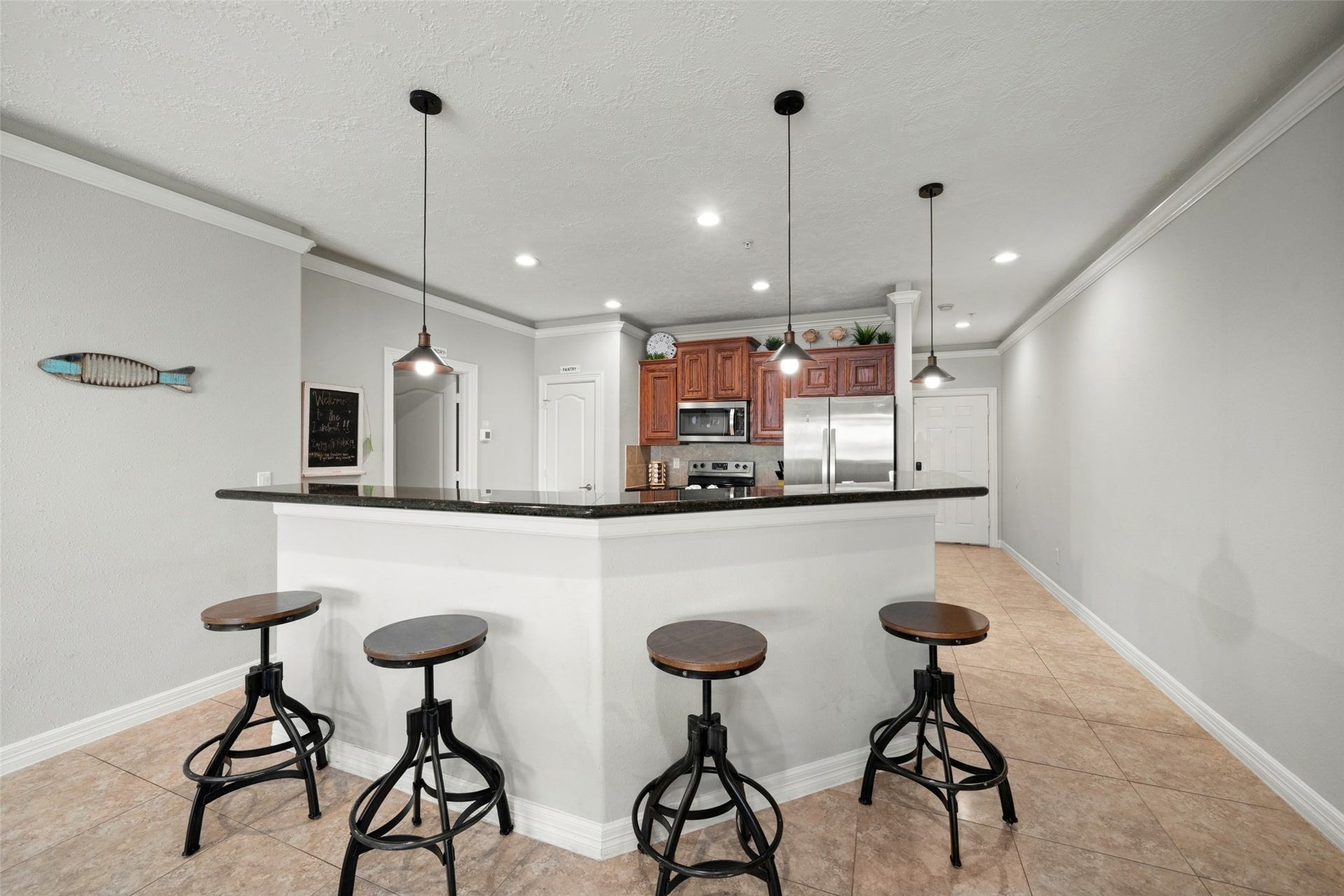 7037 Kingston Cove, #114, Willis, TX 77318 Spacious breakfast bar with seating for four, pendant lighting, and an open connection between the kitchen and living area.