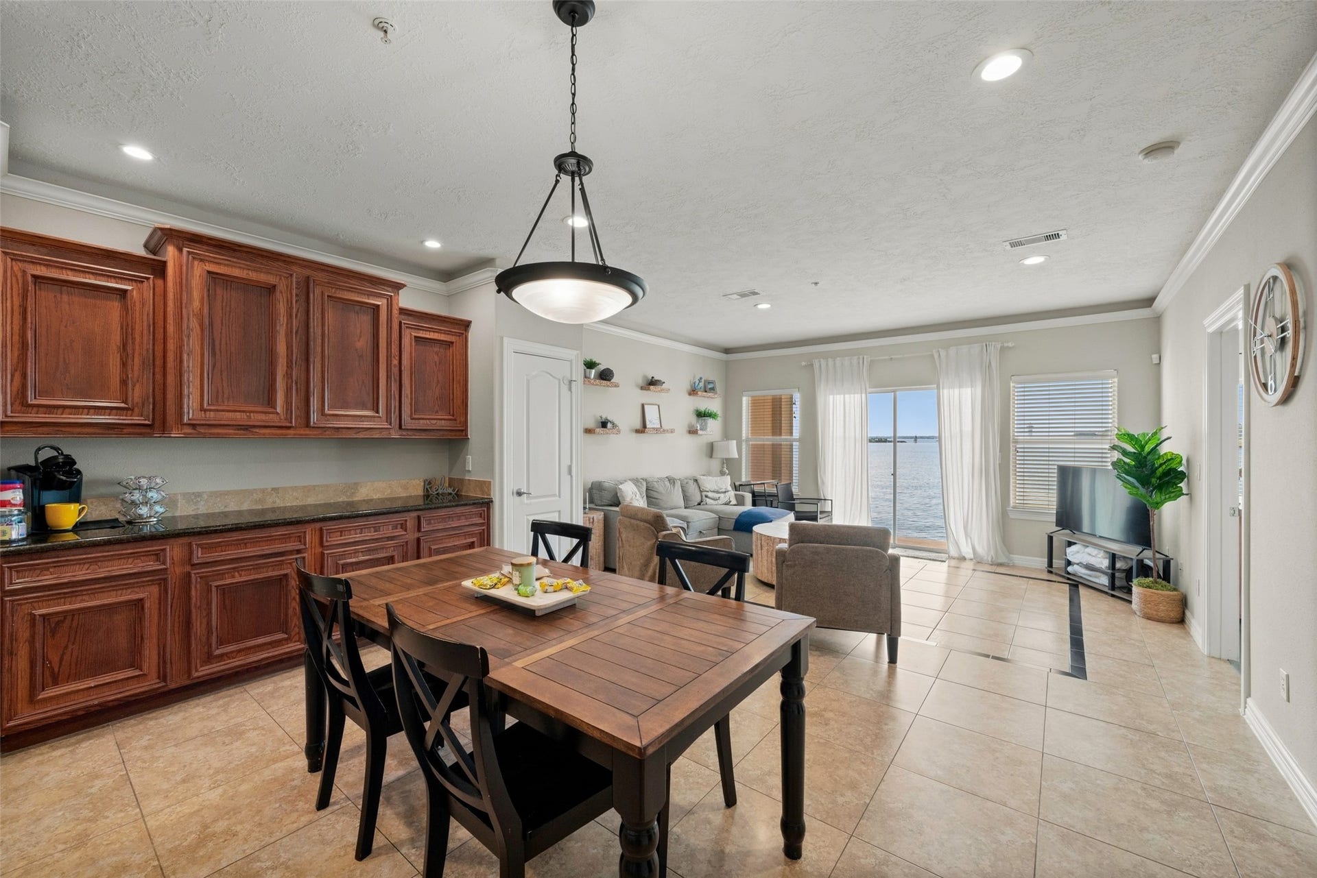 7037 Kingston Cove, #114, Willis, TX 77318 Dining space sits beside the kitchen, with an open view into the living area and toward the lakeside windows.