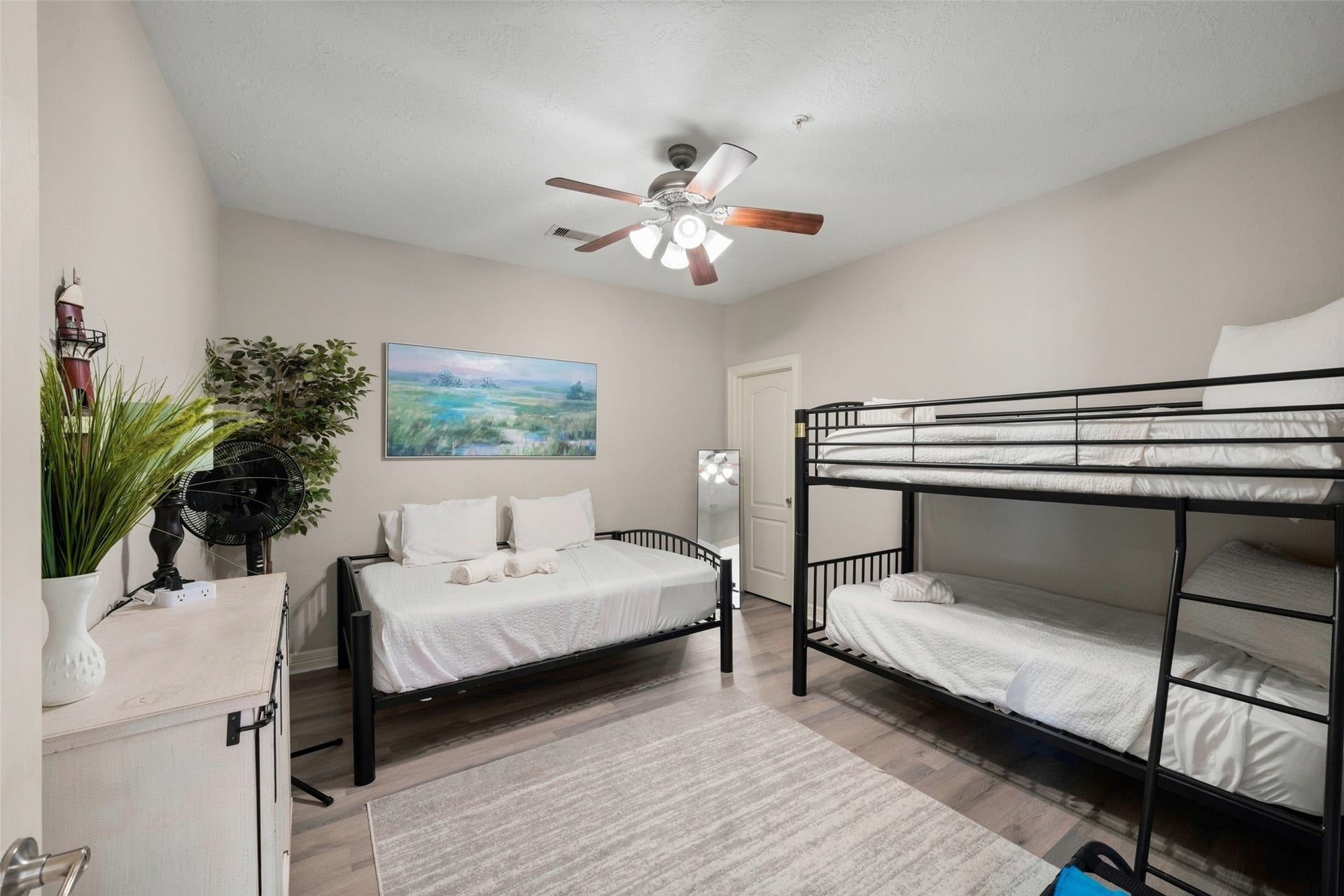 7037 Kingston Cove, #114, Willis, TX 77318 Additional bedroom features a ceiling fan, wood-look flooring, and space for bunk beds and a desk.