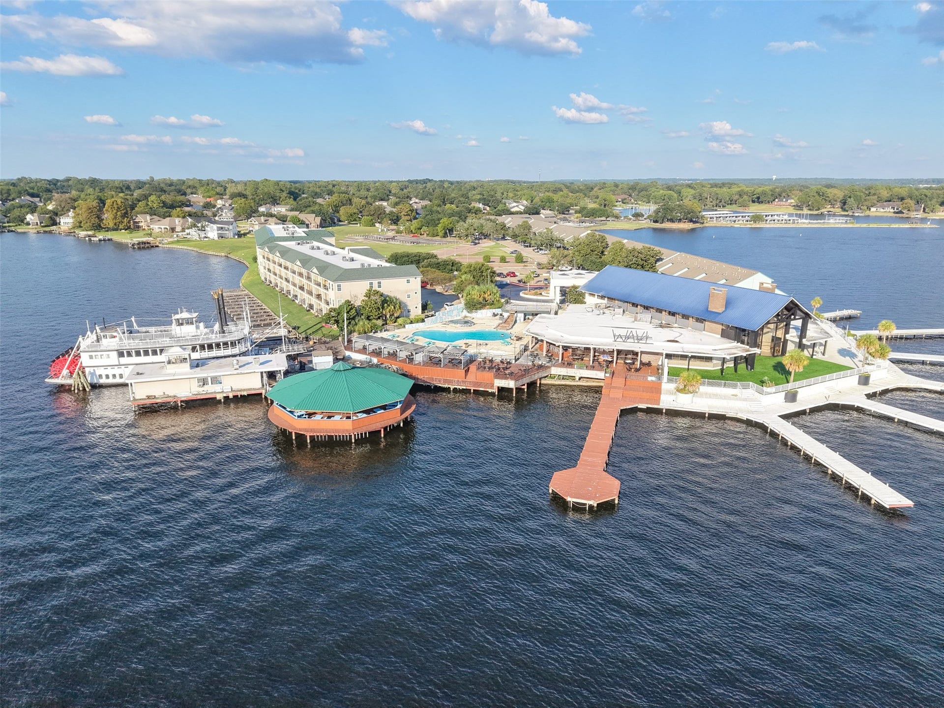 7037 Kingston Cove, #114, Willis, TX 77318 Wide aerial perspective highlights the surrounding waterfront, piers, and nearby pool with the lake in the foreground.
