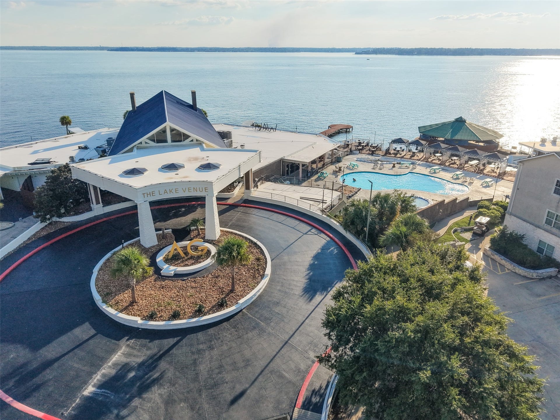 7037 Kingston Cove, #114, Willis, TX 77318 Aerial view highlights the circular drive, landscaped grounds, and nearby pool overlooking the lake
