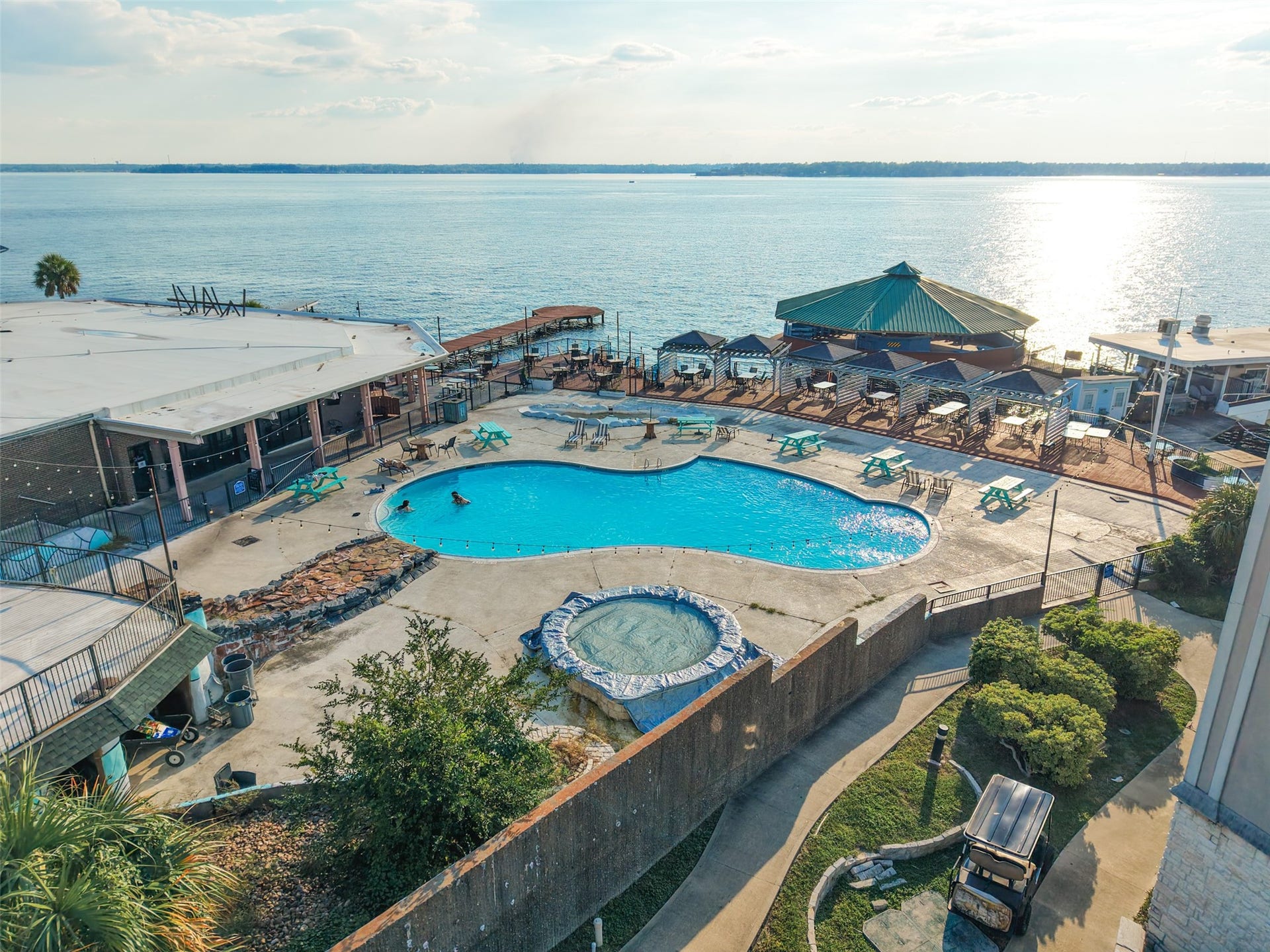 7037 Kingston Cove, #114, Willis, TX 77318 Elevated view of the lakeside pool and surrounding sundeck, with lounge seating and expansive water views.