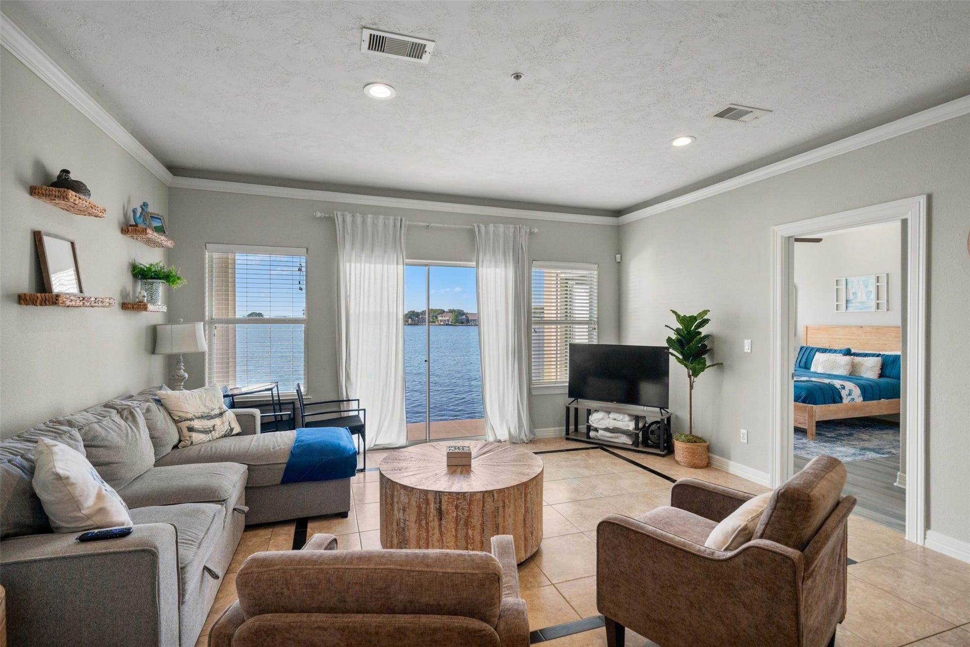7037 Kingston Cove, #114, Willis, TX 77318 Additional living room view highlights the open layout, natural light, and connection to the covered lakeside patio.