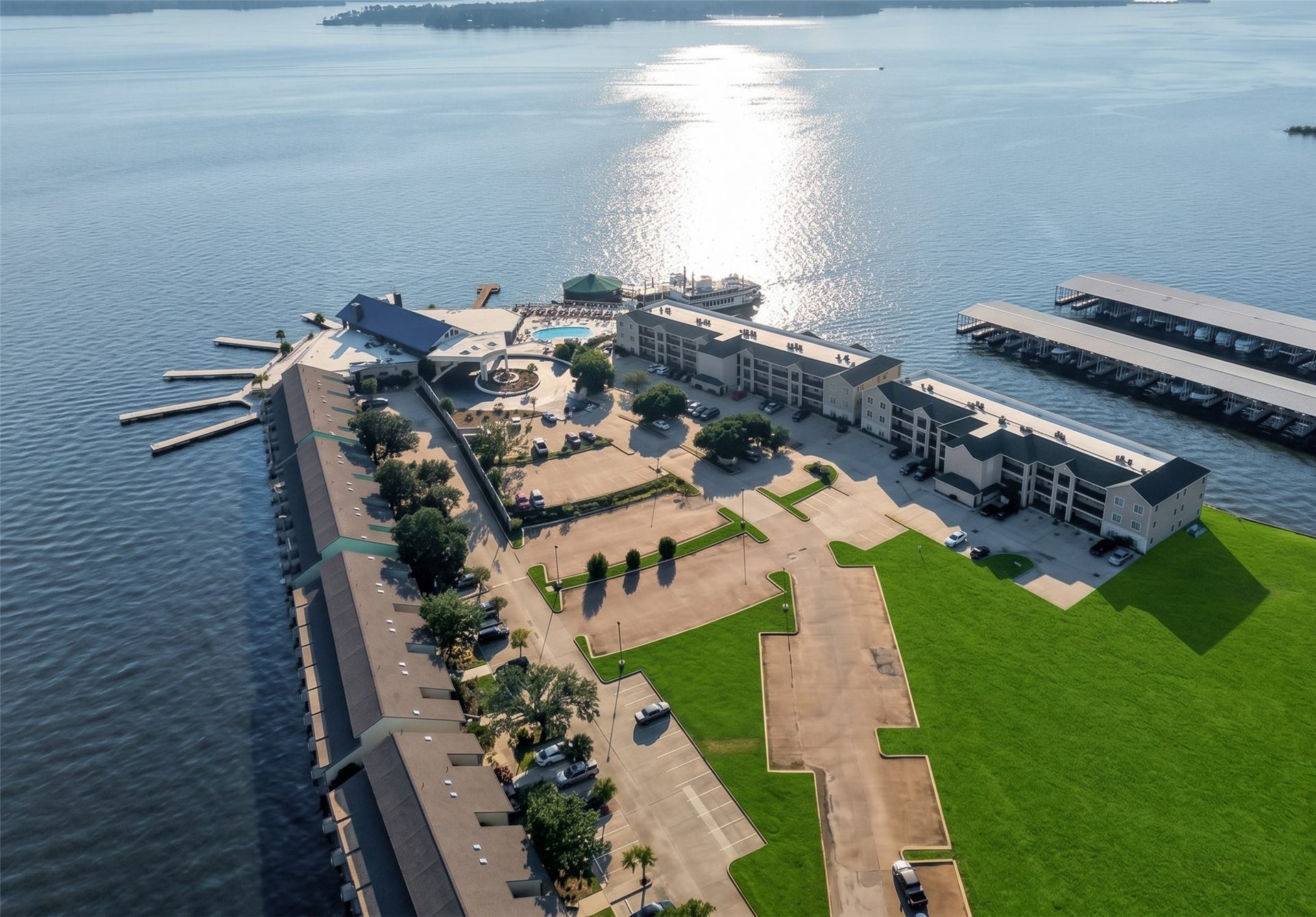 7037 Kingston Cove, #114, Willis, TX 77318 Aerial overview highlights the waterfront buildings, parking areas, landscaped grounds, and surrounding green space.
