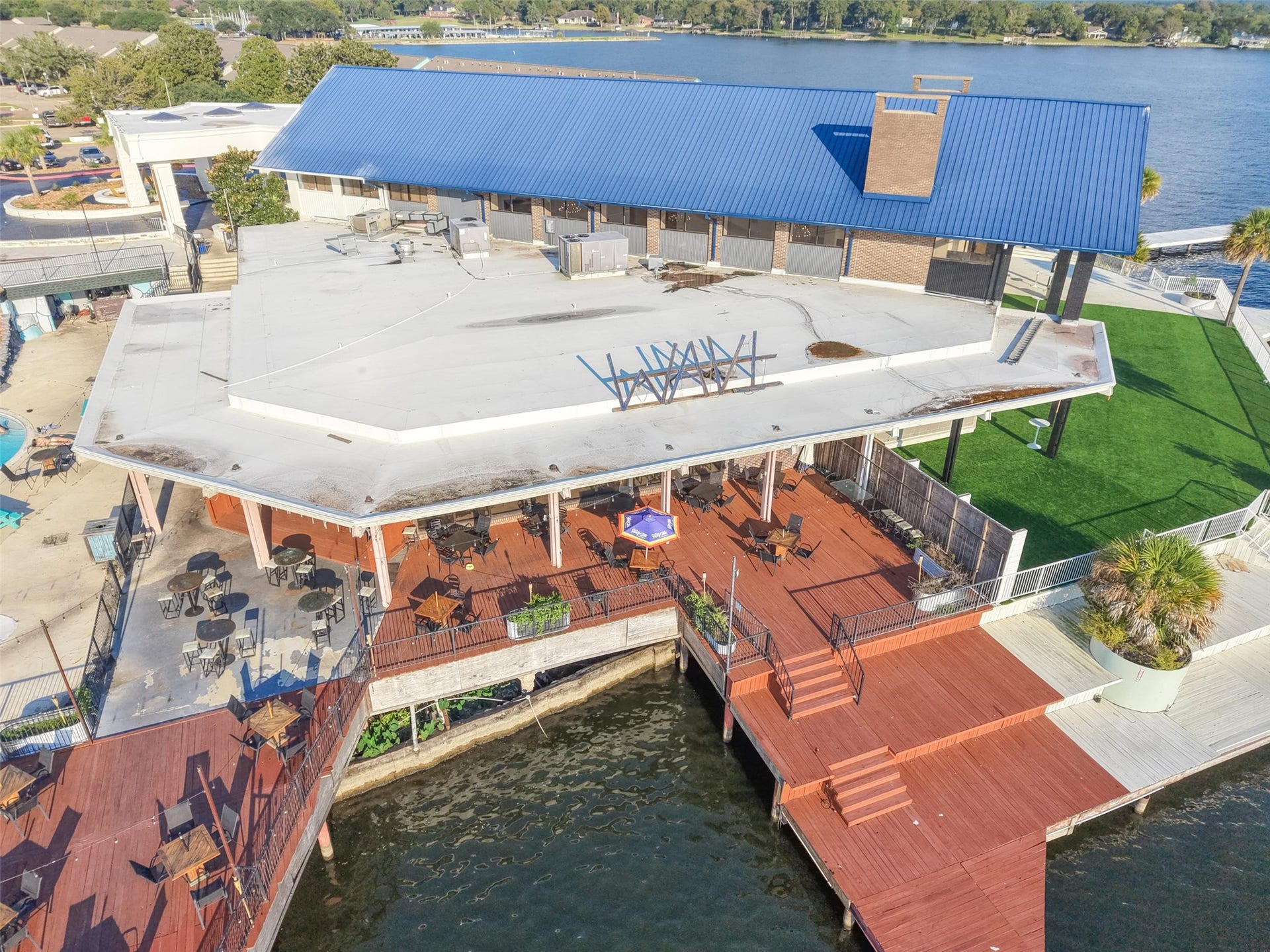 7037 Kingston Cove, #114, Willis, TX 77318 Overhead view showcases a spacious waterfront deck with outdoor seating beside the marina.
