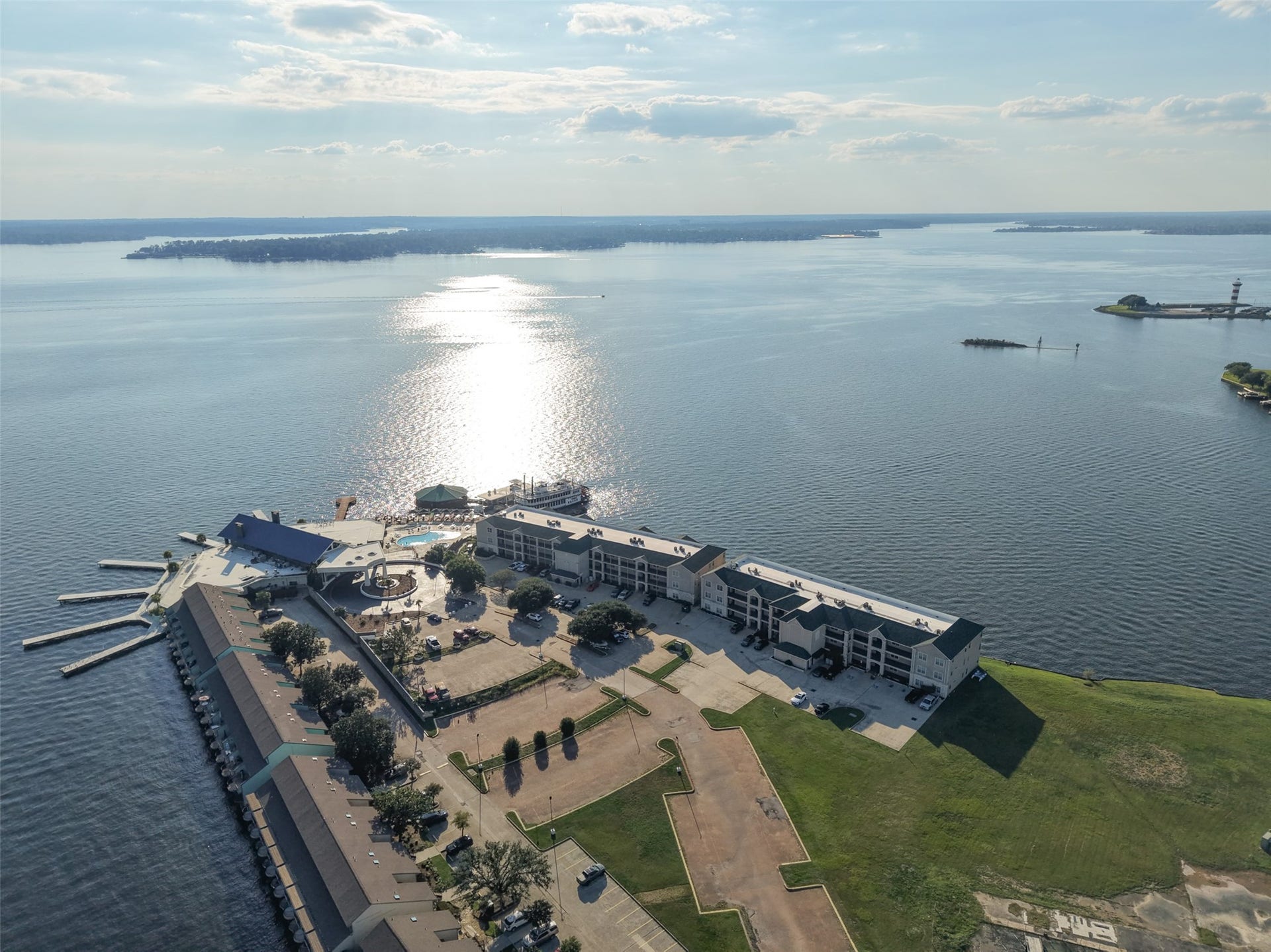 7037 Kingston Cove, #114, Willis, TX 77318 Aerial perspective showcases the condominium buildings along the lake, surrounding green space, and nearby marina.