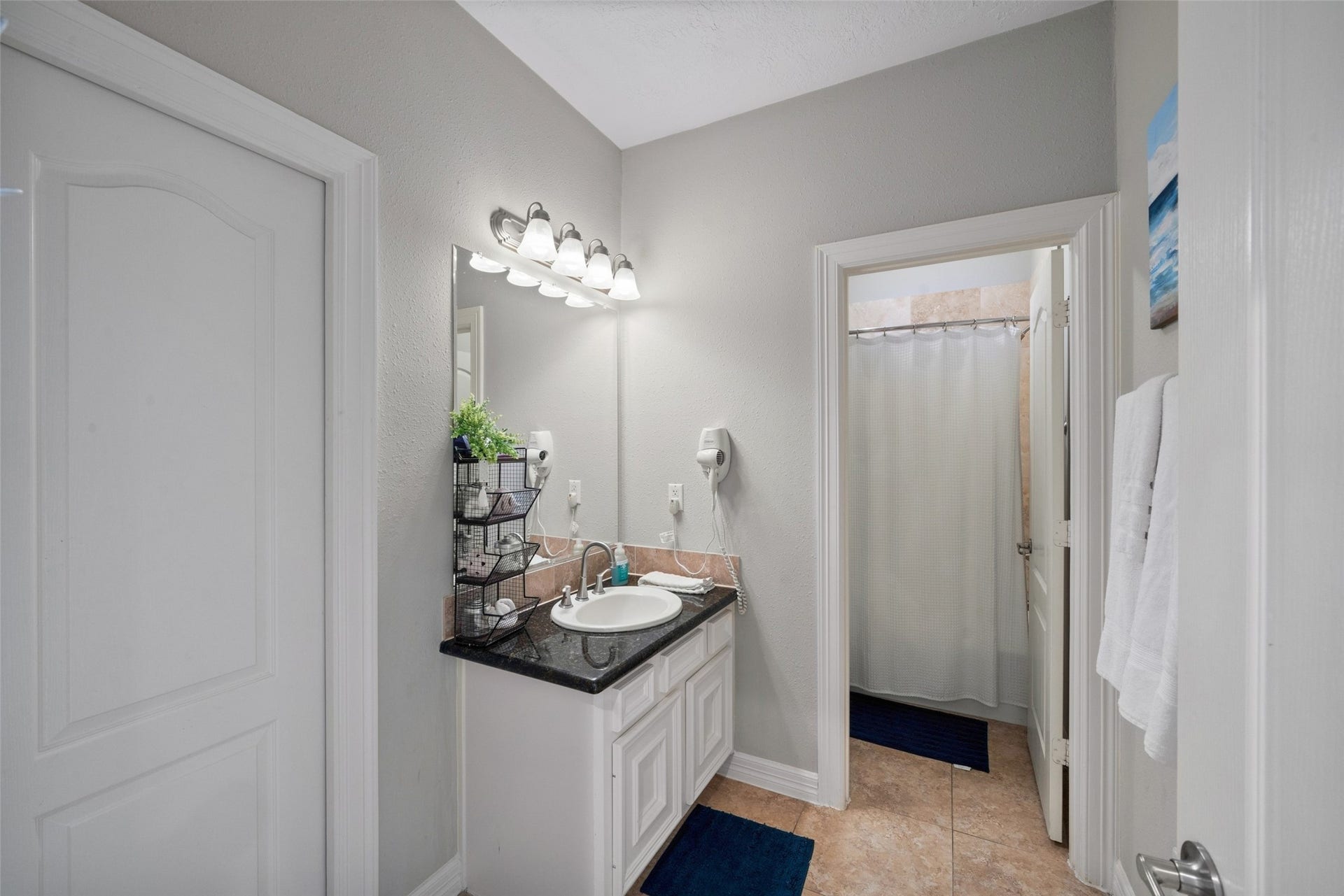 7037 Kingston Cove, #114, Willis, TX 77318 Bathroom includes a vanity with storage, decorative lighting, and an adjoining tub and shower area.