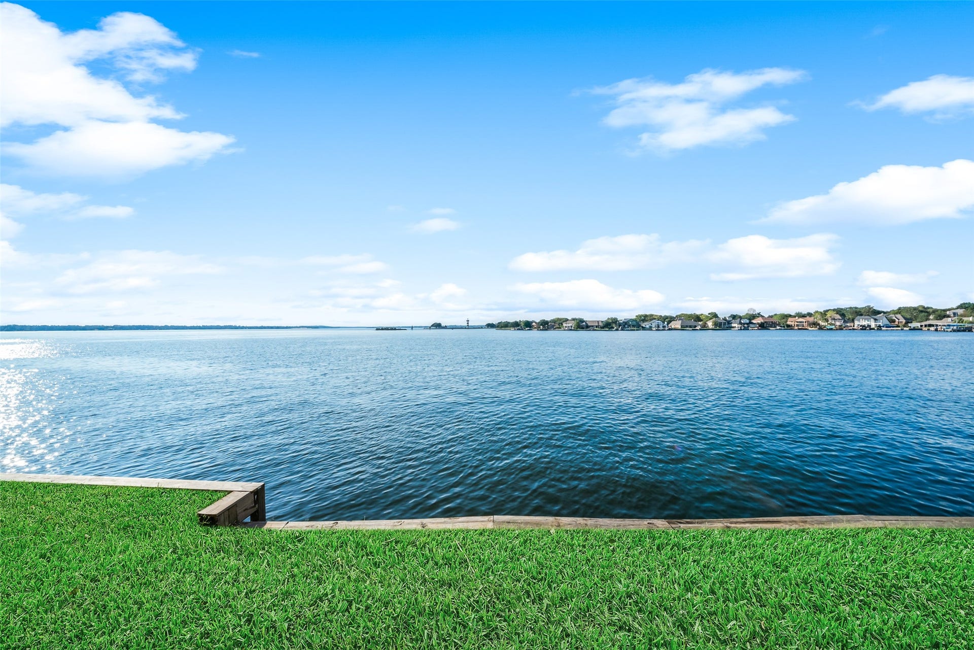 7037 Kingston Cove, #114, Willis, TX 77318 Sweeping lake views with a grassy shoreline and open skies create a scenic backdrop.