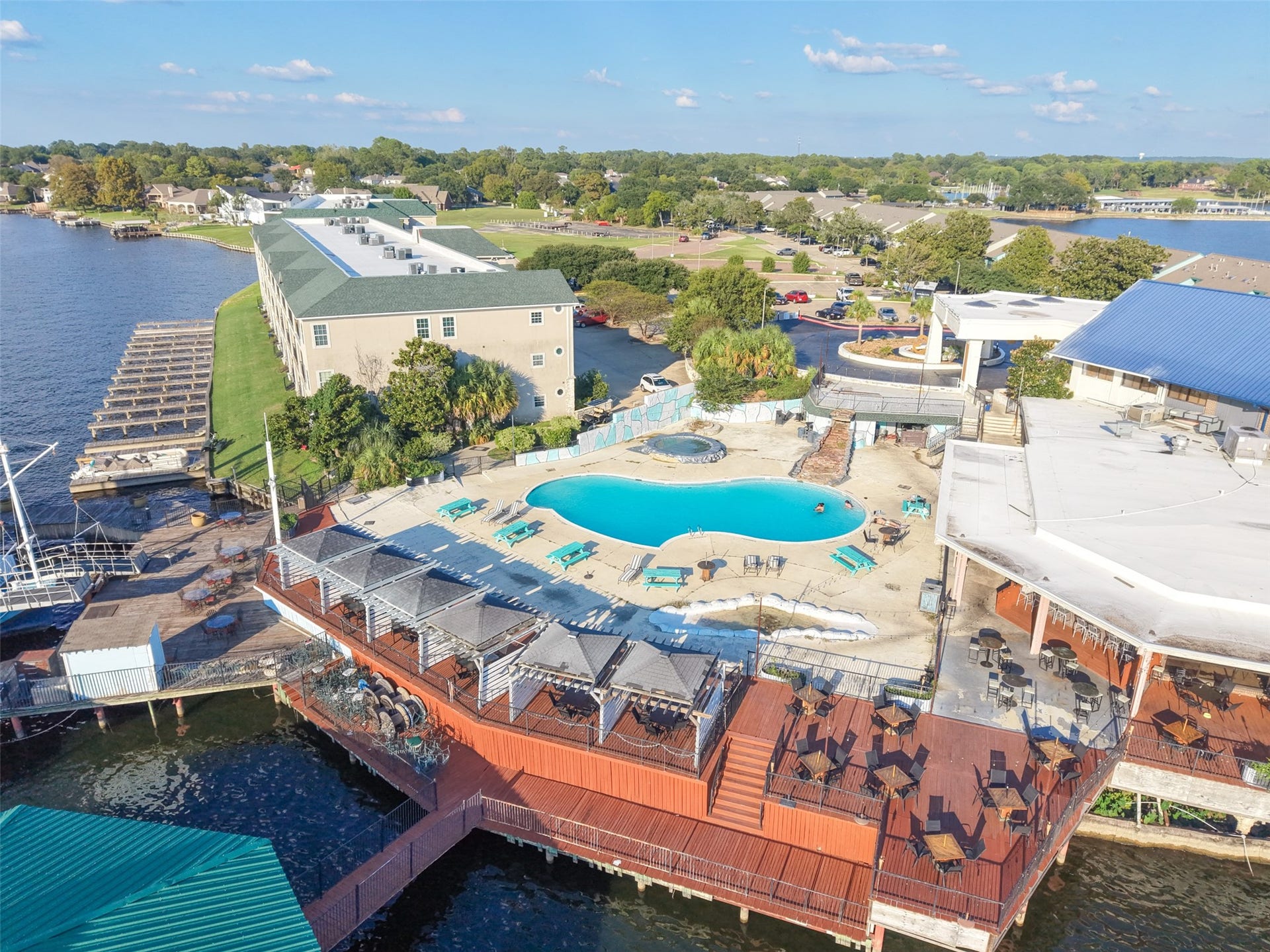 7037 Kingston Cove, #114, Willis, TX 77318 Aerial perspective captures the pool, outdoor gathering areas, and waterfront deck along the shoreline