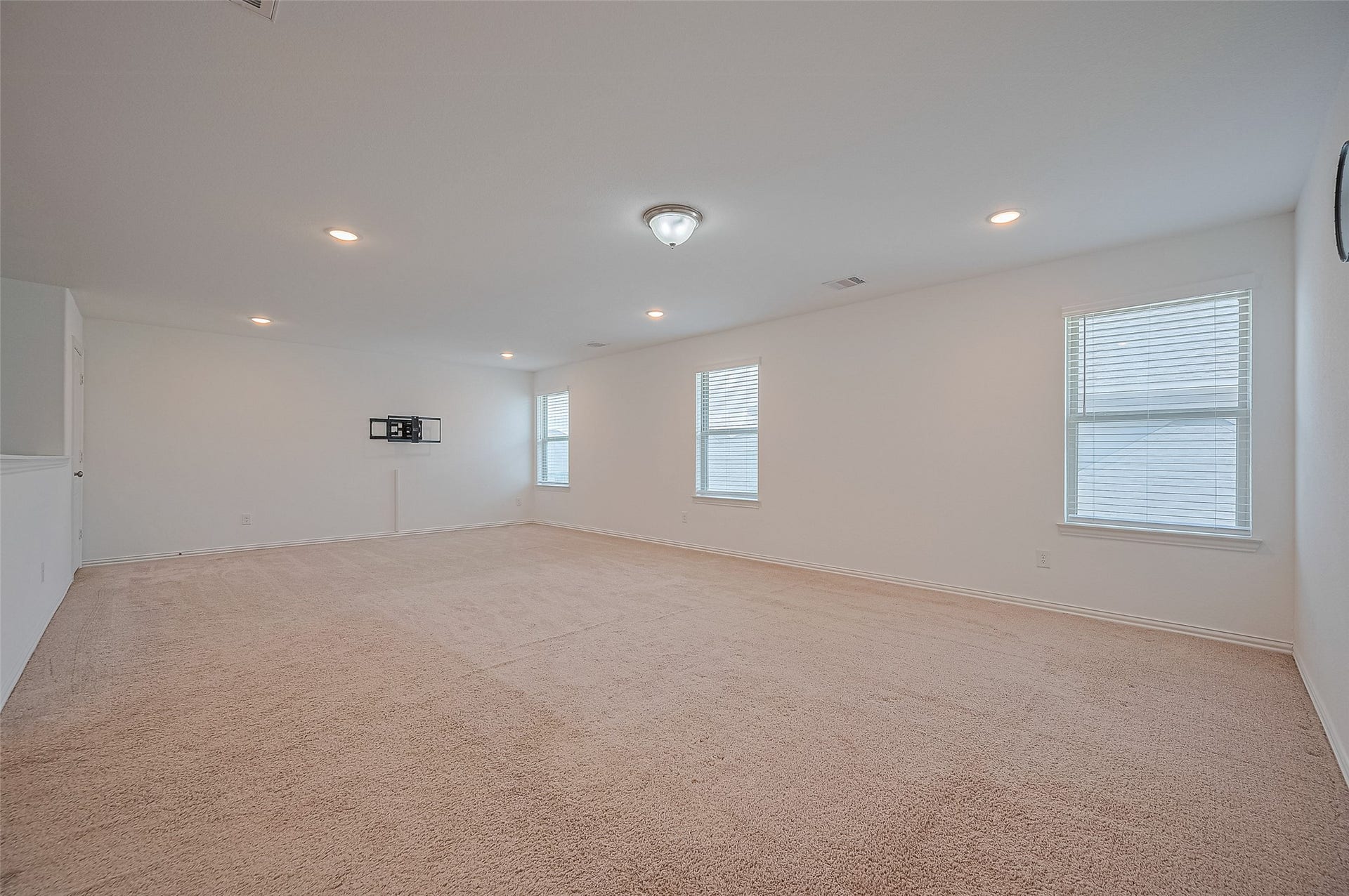 31326 Whitfield Court, Fulshear, TX 77441 Family room with neutral carpeting and white walls.