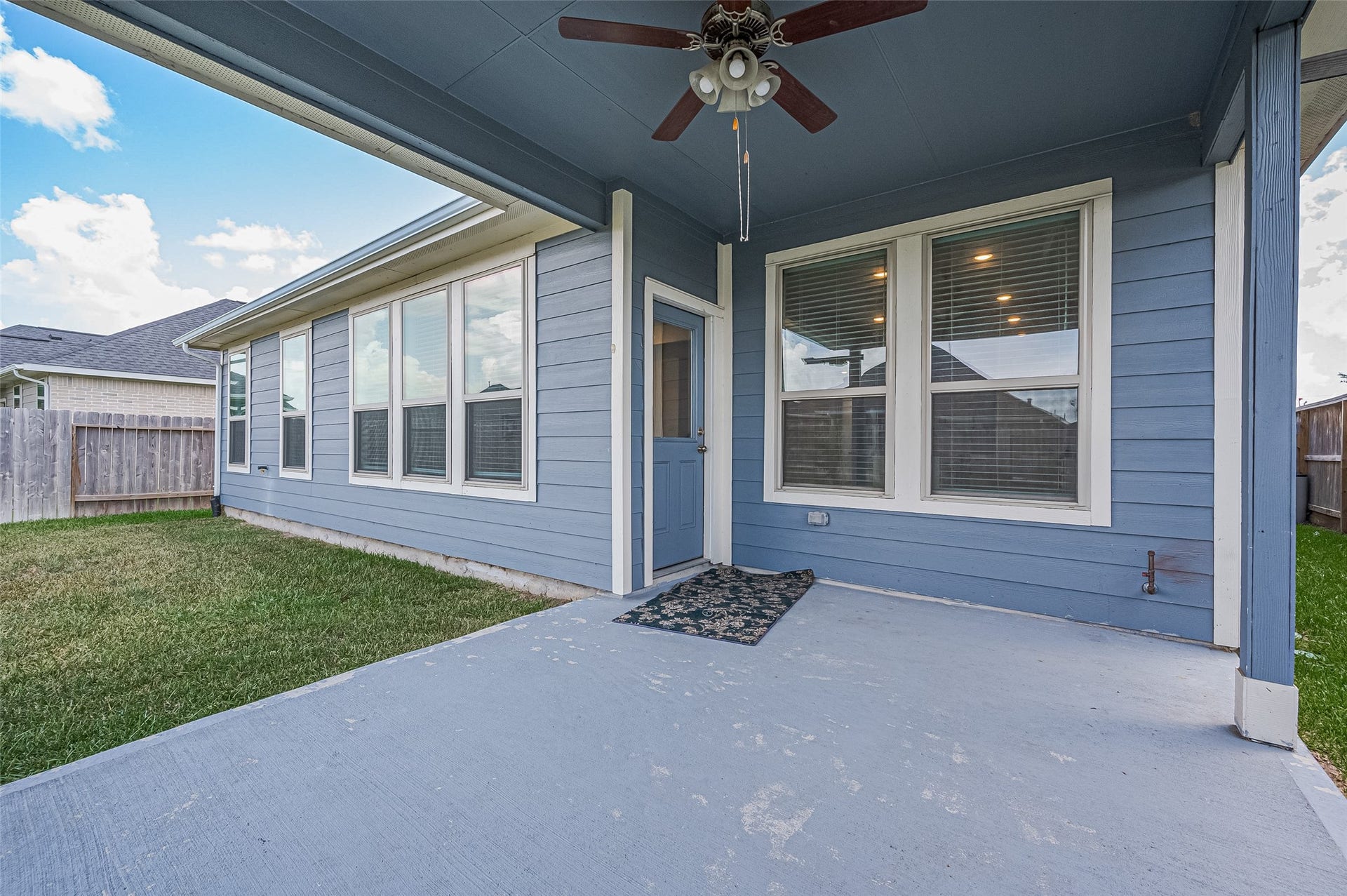 31326 Whitfield Court, Fulshear, TX 77441 Cozy covered patio with a concrete flooring and adjacent grassy yard area.