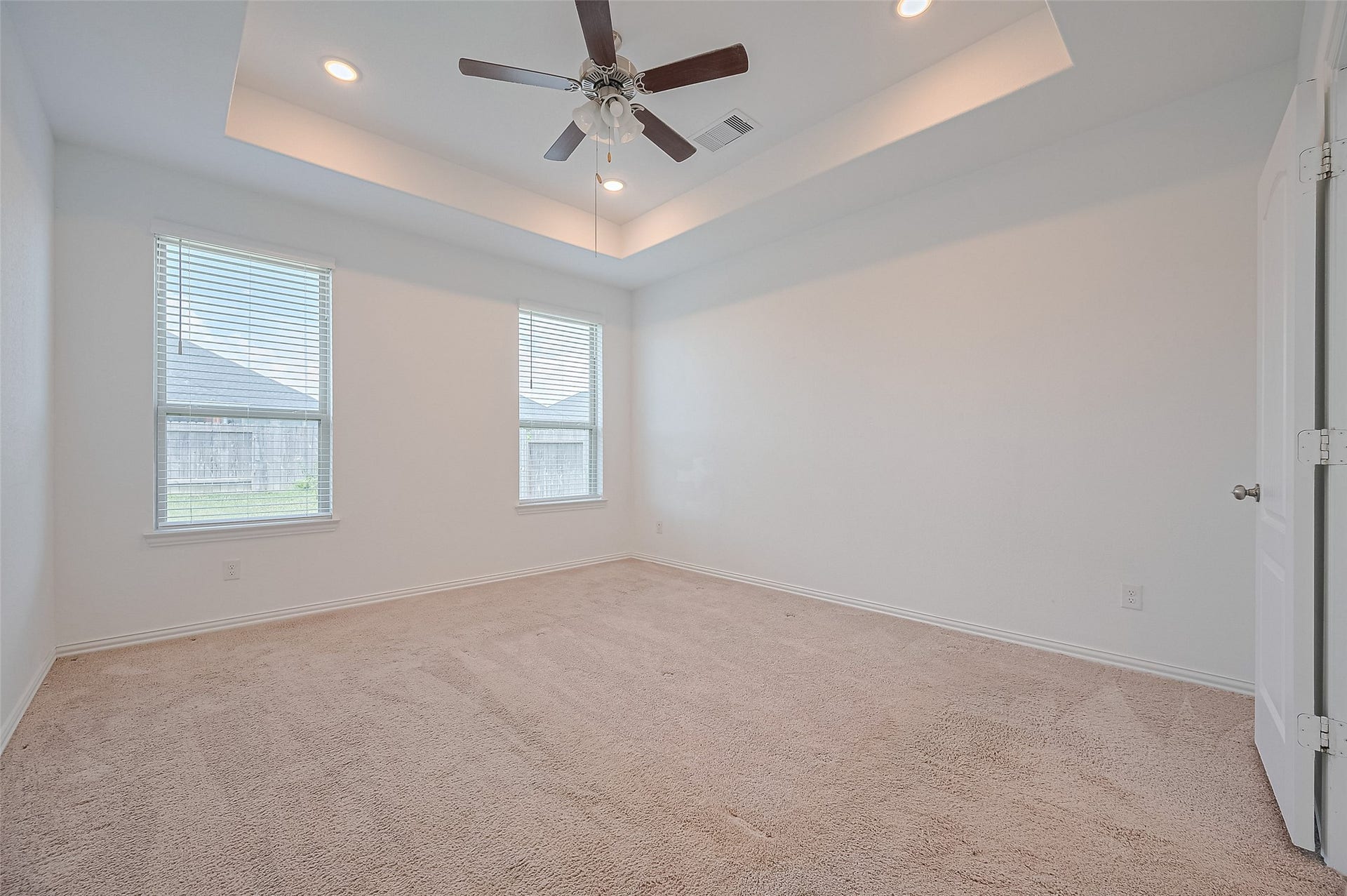 31326 Whitfield Court, Fulshear, TX 77441 Primary bedroom features plush carpeting and a tray ceiling with recessed lighting.