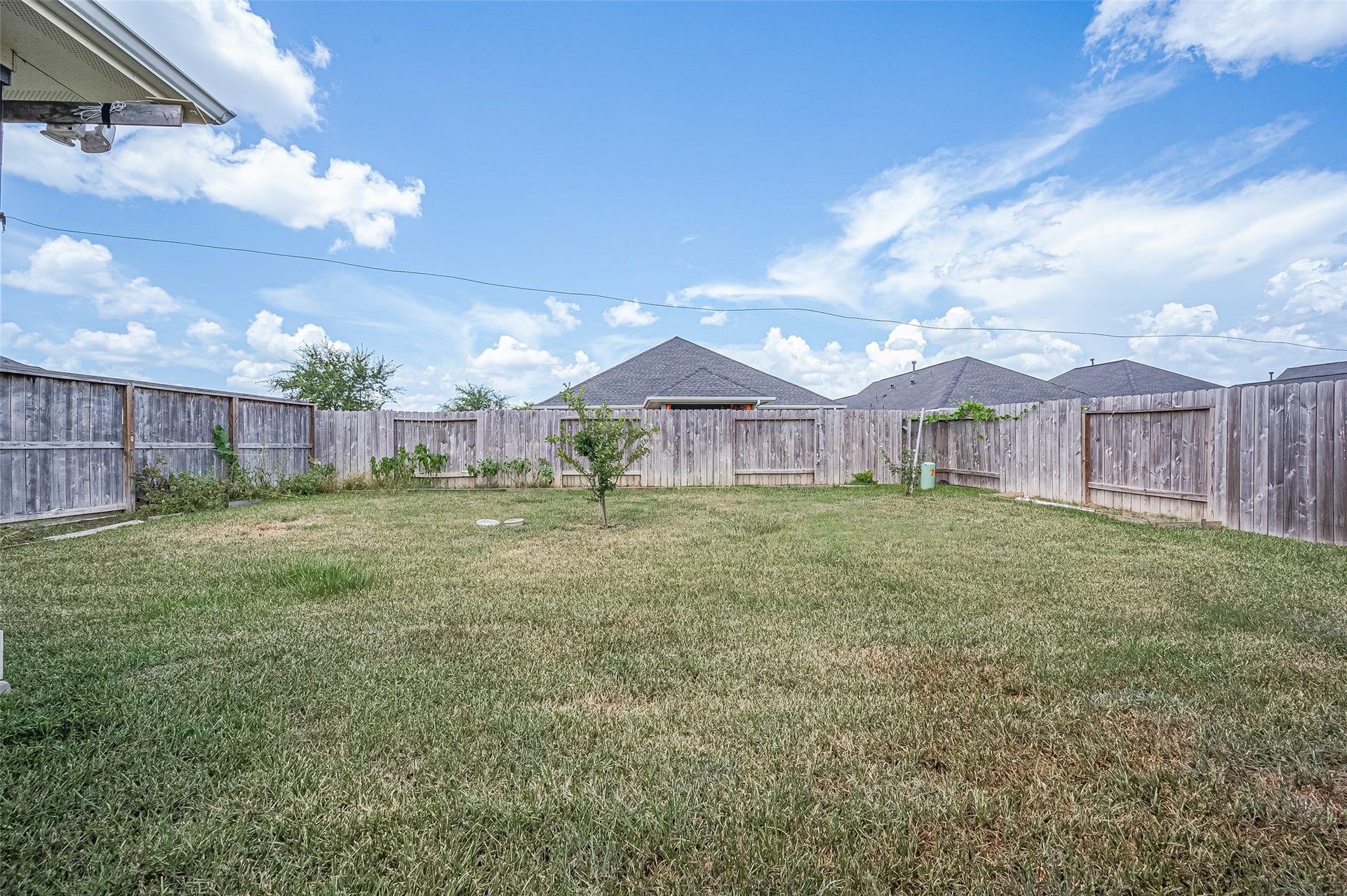 31326 Whitfield Court, Fulshear, TX 77441 Expansive backyard with a pristine lawn and wooden fence.