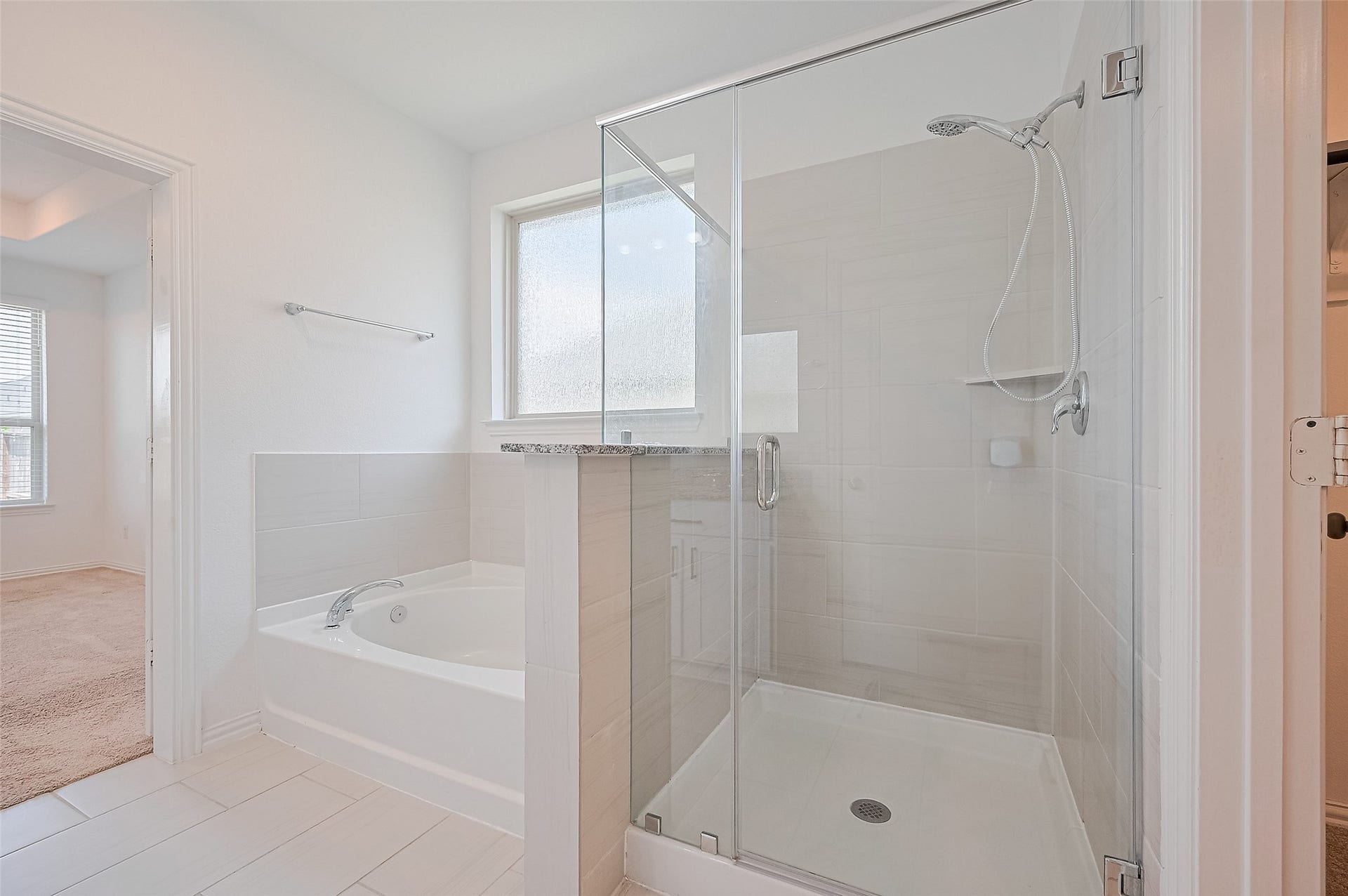 31326 Whitfield Court, Fulshear, TX 77441 A spacious glass-enclosed shower and a separate soaking tub.