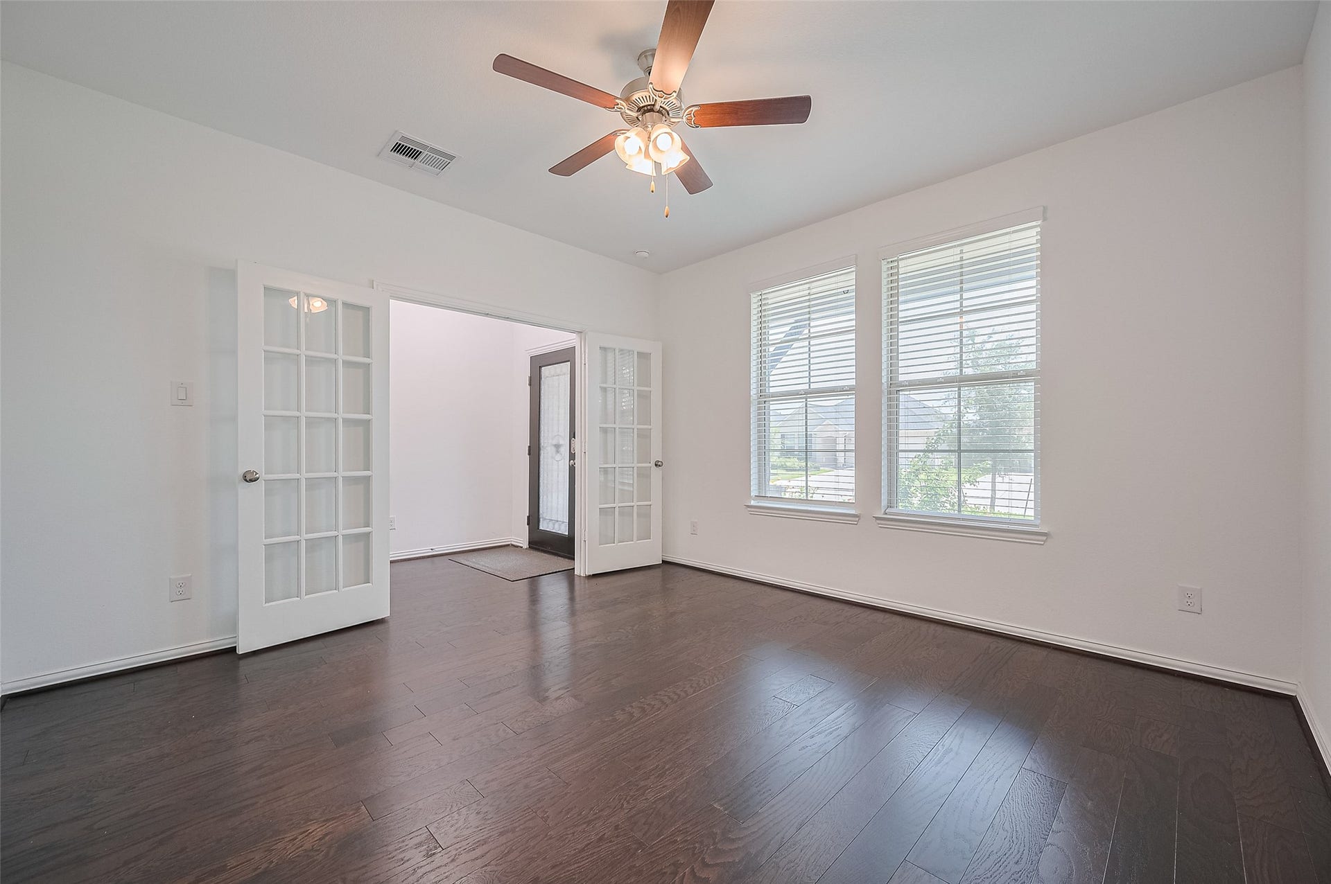 31326 Whitfield Court, Fulshear, TX 77441 Elegant dark hardwood floors, large windows, and stylish French door.