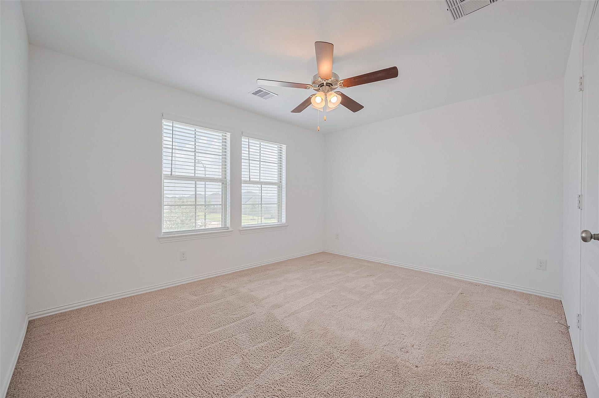 31326 Whitfield Court, Fulshear, TX 77441 Bedroom with clean white walls and soft carpet flooring.