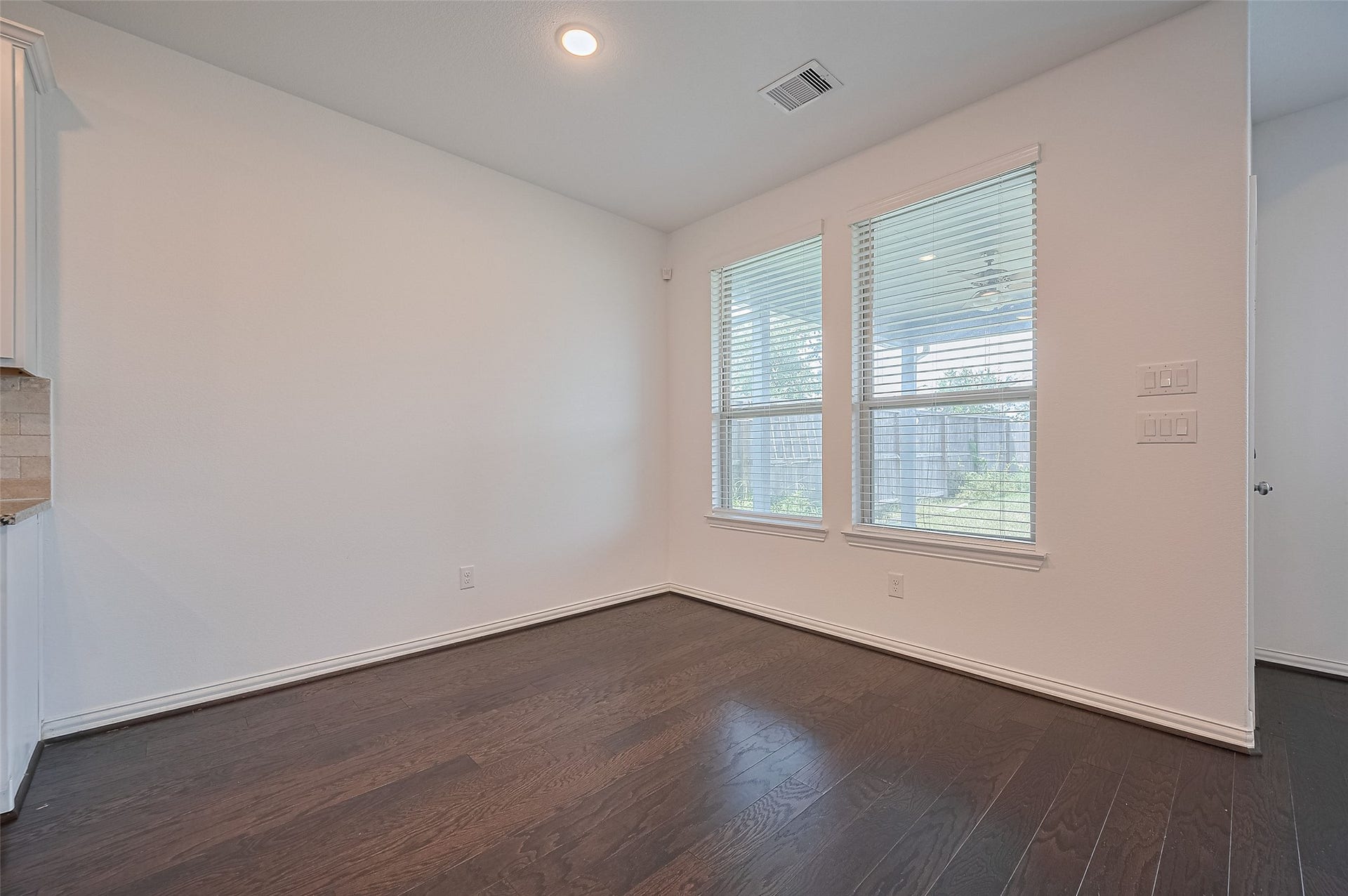 31326 Whitfield Court, Fulshear, TX 77441 Bright and spacious dining area featuring two windows and wooden floor.
