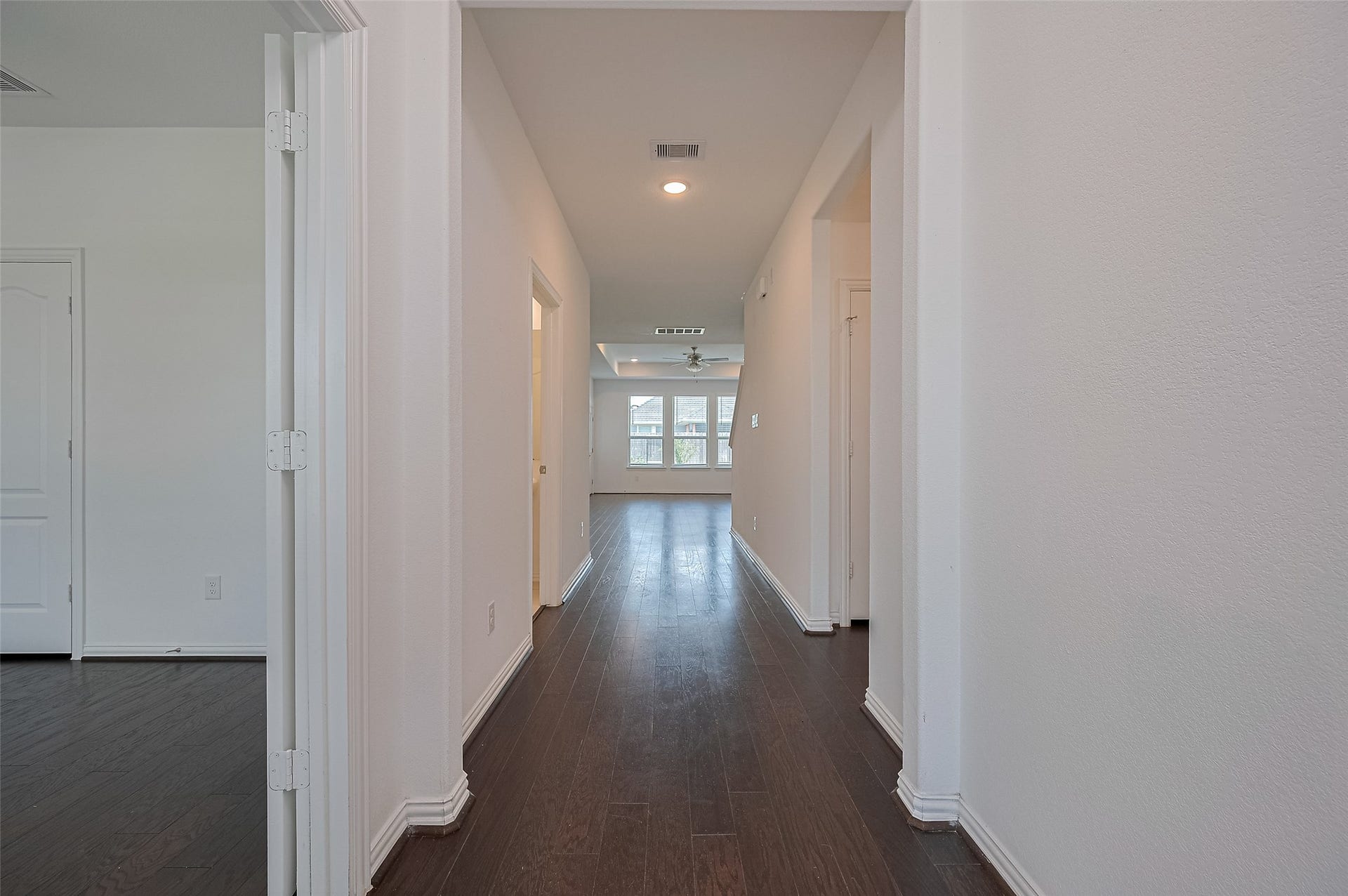 31326 Whitfield Court, Fulshear, TX 77441 Bright, open hallway with dark wood floors leading to a spacious living area.