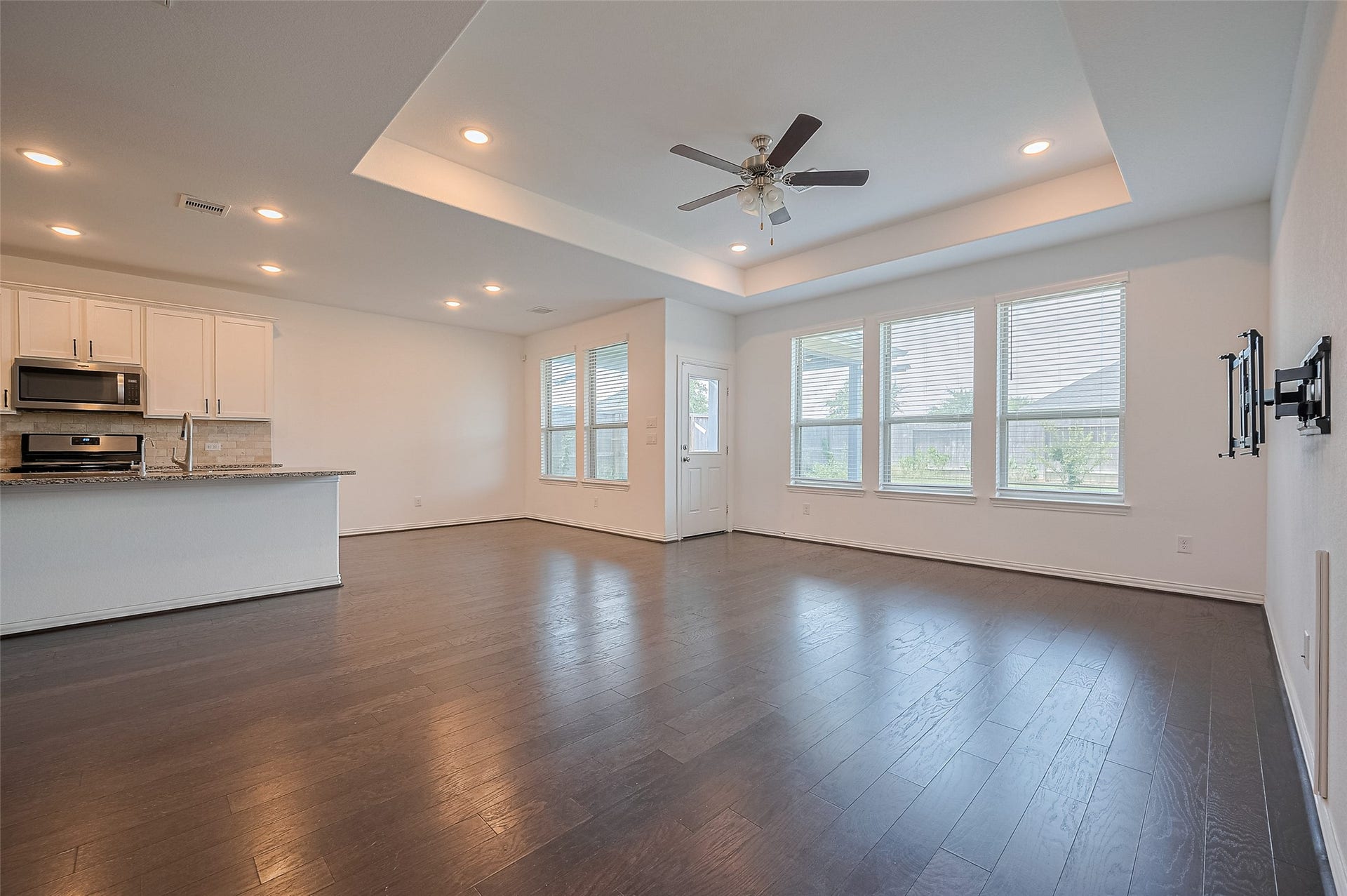 31326 Whitfield Court, Fulshear, TX 77441 Open-concept living room with, a ceiling fan and a door leading to the backyard.