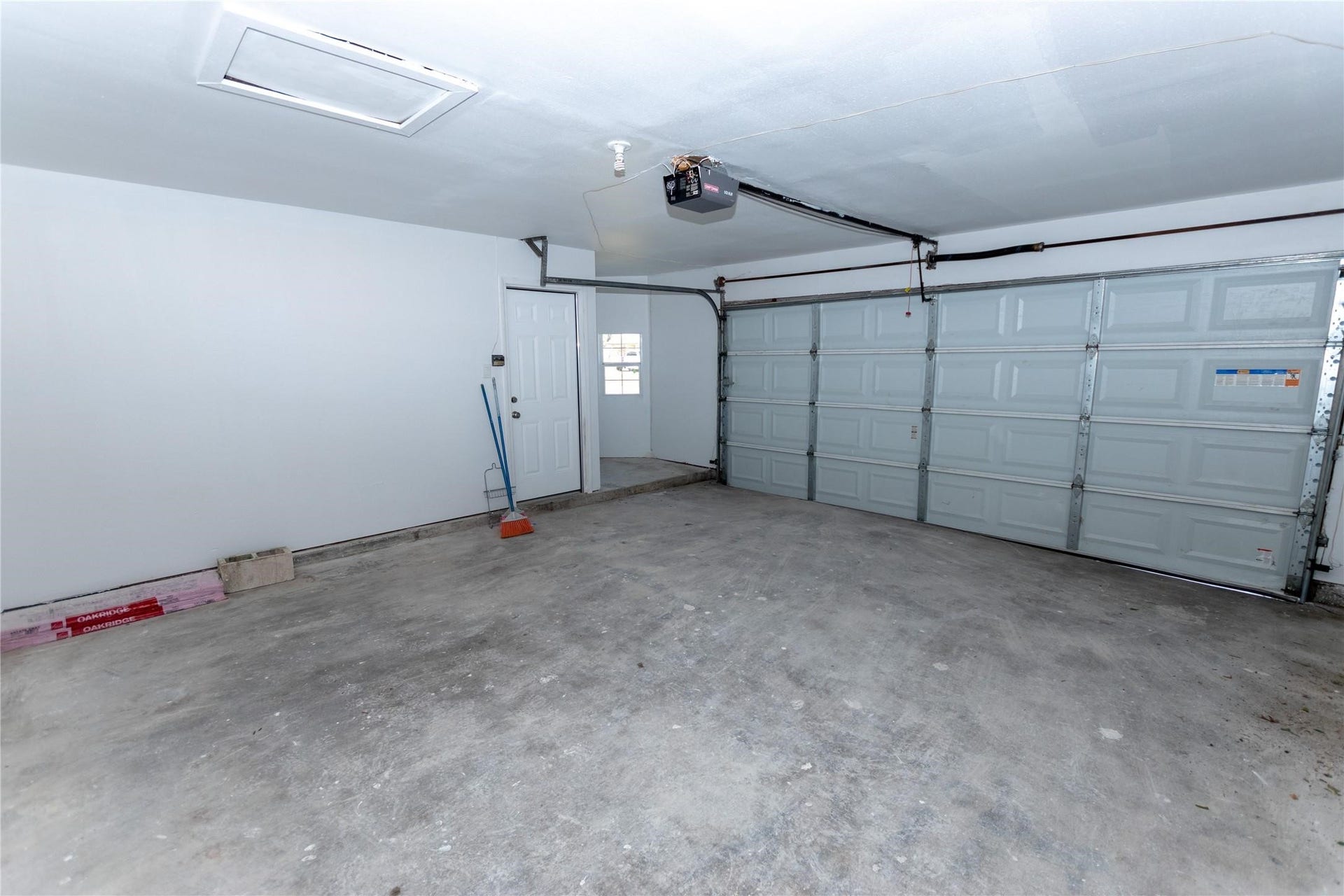 5610 Wallis Trail Court, Houston, TX 77049 Spacious two-car garage with plenty of storage potential, featuring a clean concrete floor and easy access through a side door and automatic garage door.