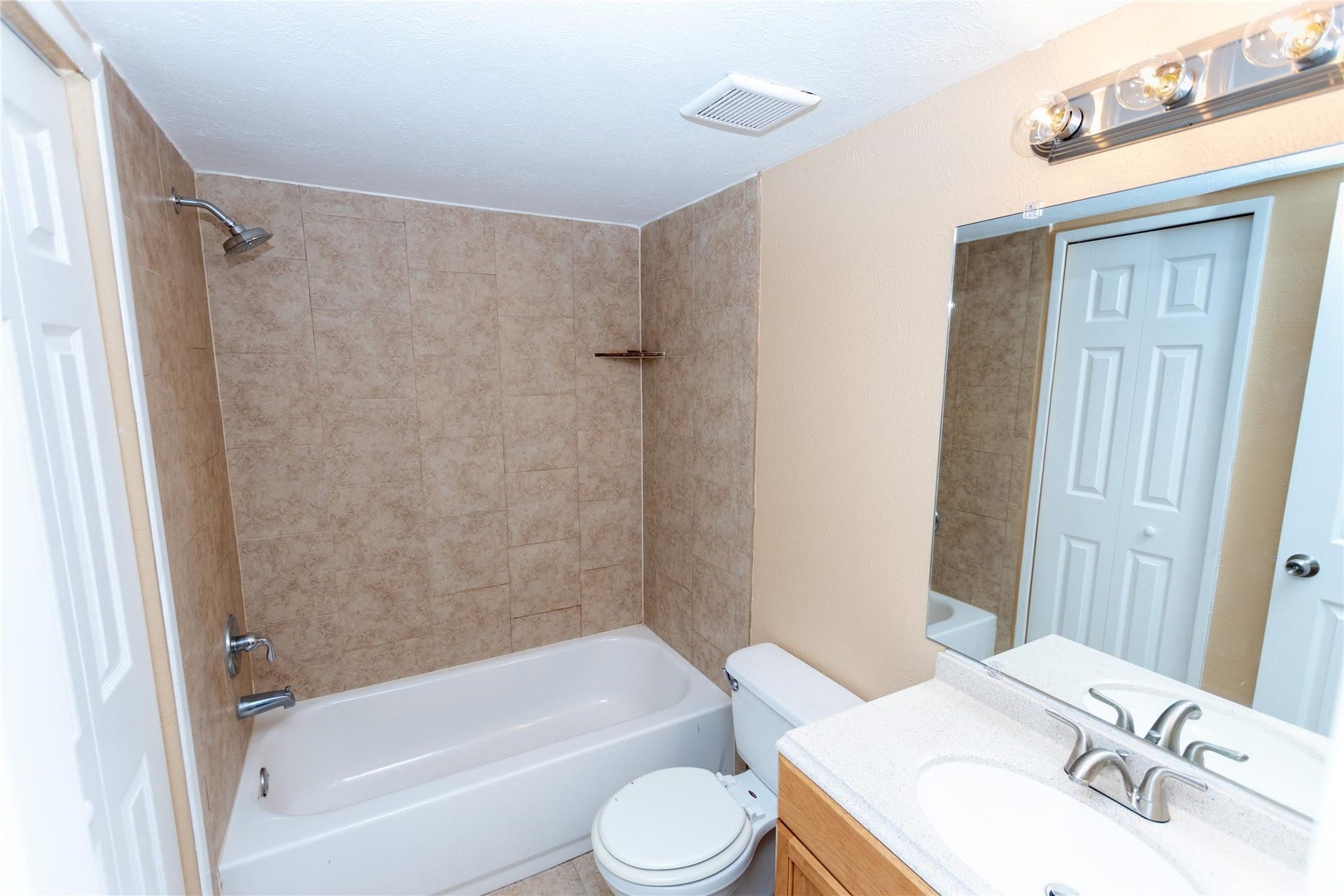 5610 Wallis Trail Court, Houston, TX 77049 Charming bathroom featuring a tiled shower-tub combo, a sleek vanity with a modern faucet, and a large mirror enhancing the sense of space.