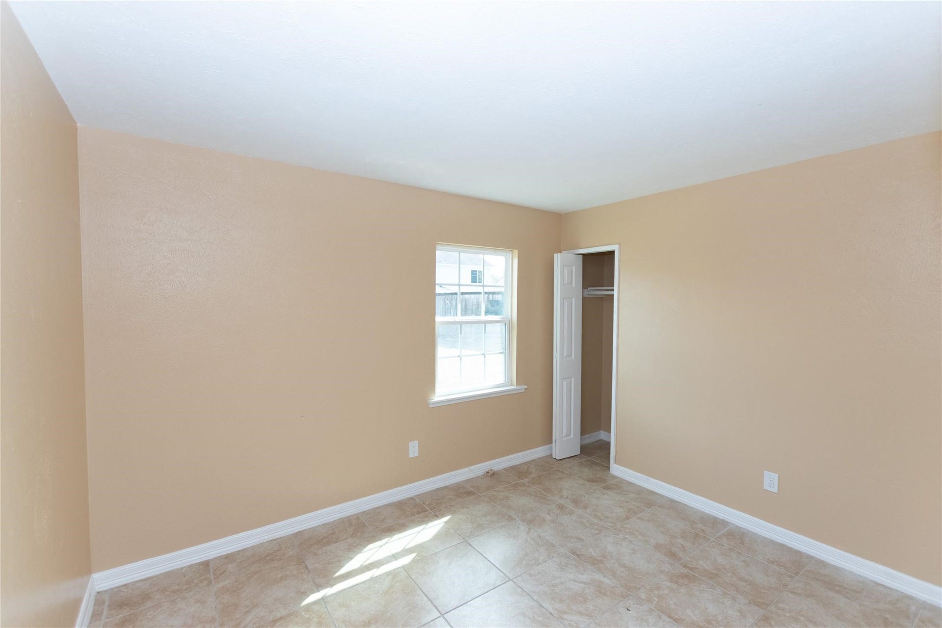 5610 Wallis Trail Court, Houston, TX 77049 Bright and inviting room with neutral walls, a window for natural light, and a convenient closet, perfect for customization.