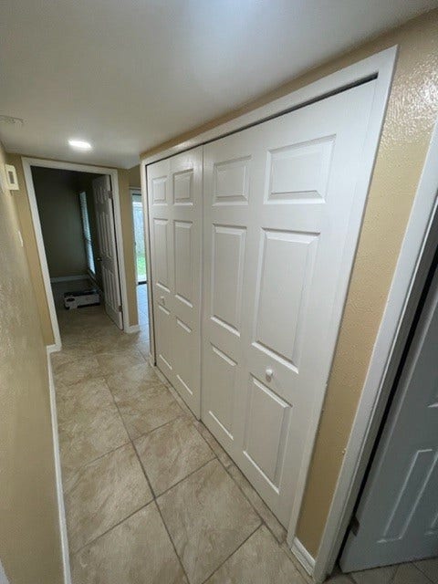 5610 Wallis Trail Court, Houston, TX 77049 Bright hallway with tiled flooring and ample closet space, leading to a cozy room with natural light.