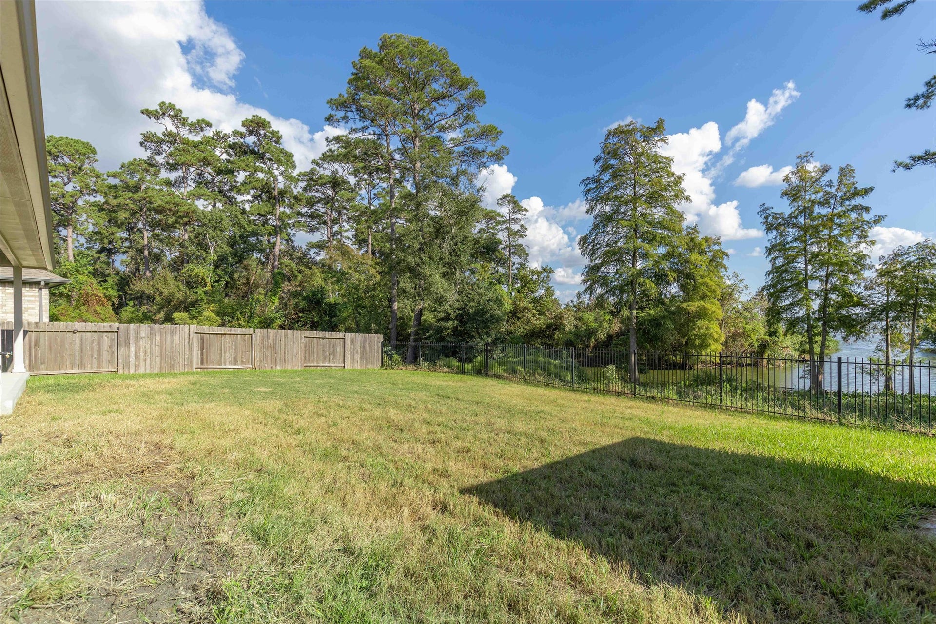 Spacious backyard with lush greenery and a scenic view of the water, perfect for outdoor relaxation and entertaining.