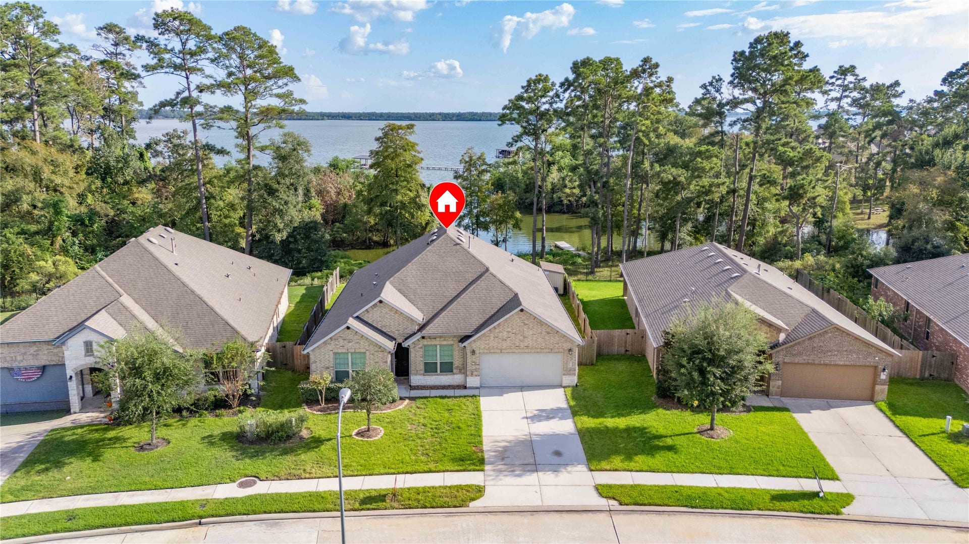 Charming single-story brick home with a well-maintained lawn, nestled in a serene neighborhood with picturesque lake views.