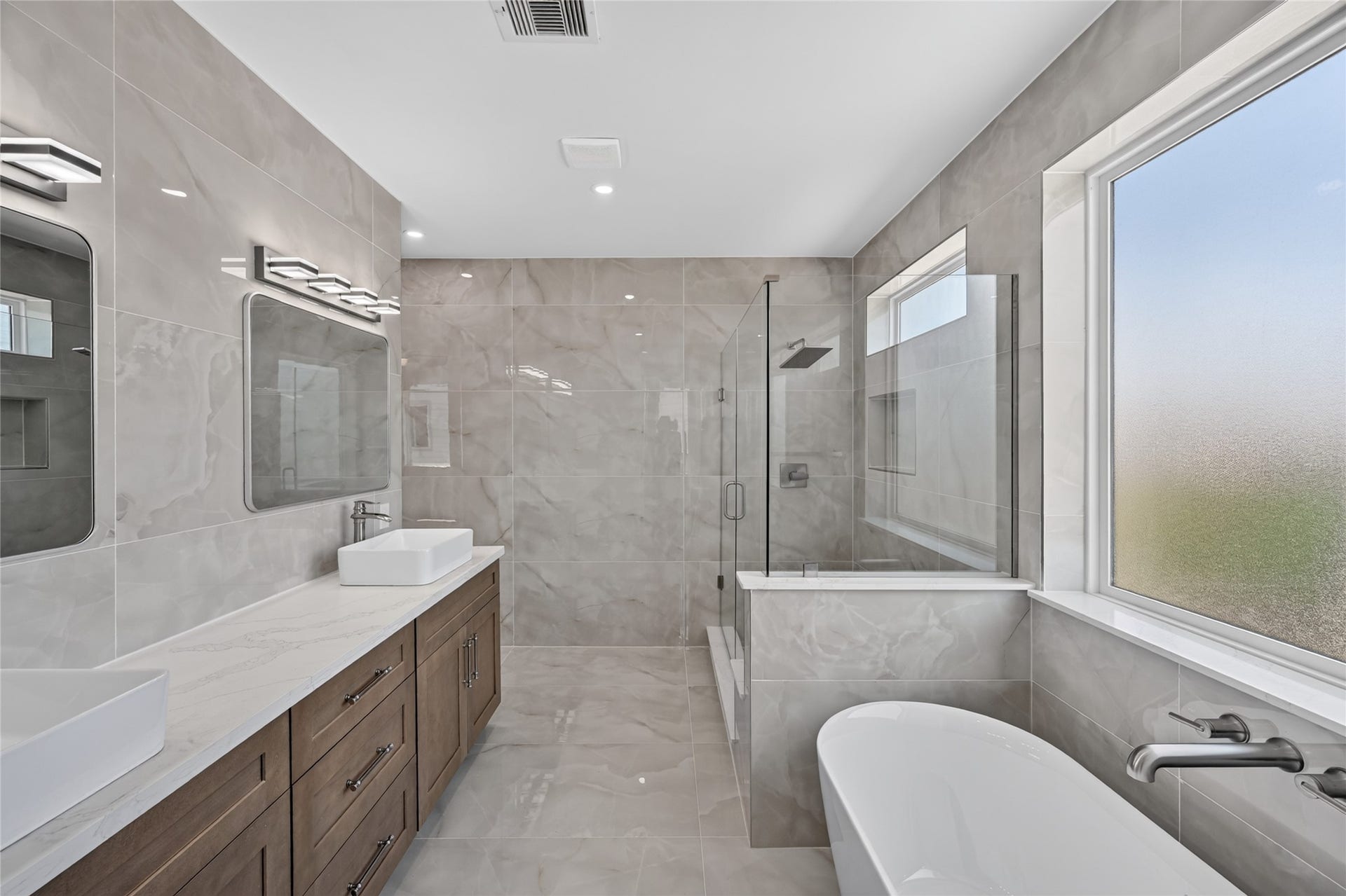 1424 W 23rd Street, #B, Houston, TX 77008 Primary Bathroom with creamy beige tile and custom cabinets with brush nickel hardware