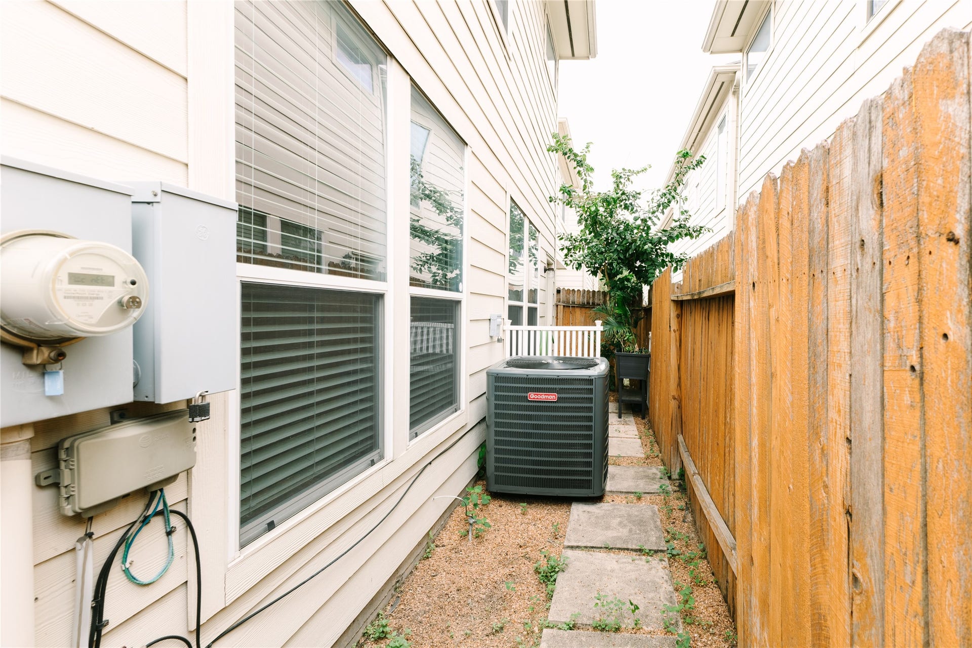 1710 Aden Mist Drive, Houston, TX 77003 Charming side yard features a practical pathway with stepping stones, neatly lined with a wooden fence, and houses the home's 2024 HVAC unit for efficient climate control.