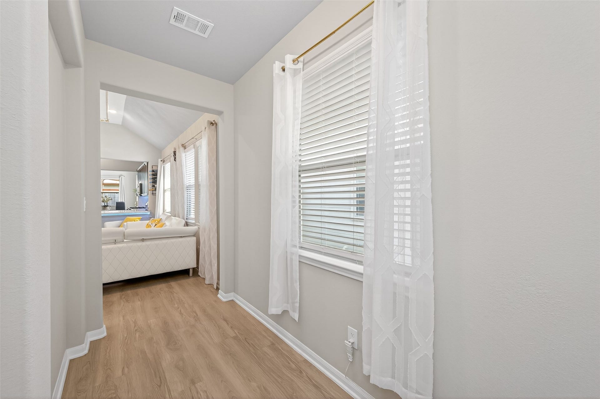 22409 Kinley Street, New Caney, TX 77357 Bright and inviting hallway with light wood flooring, leading to a cozy living area.