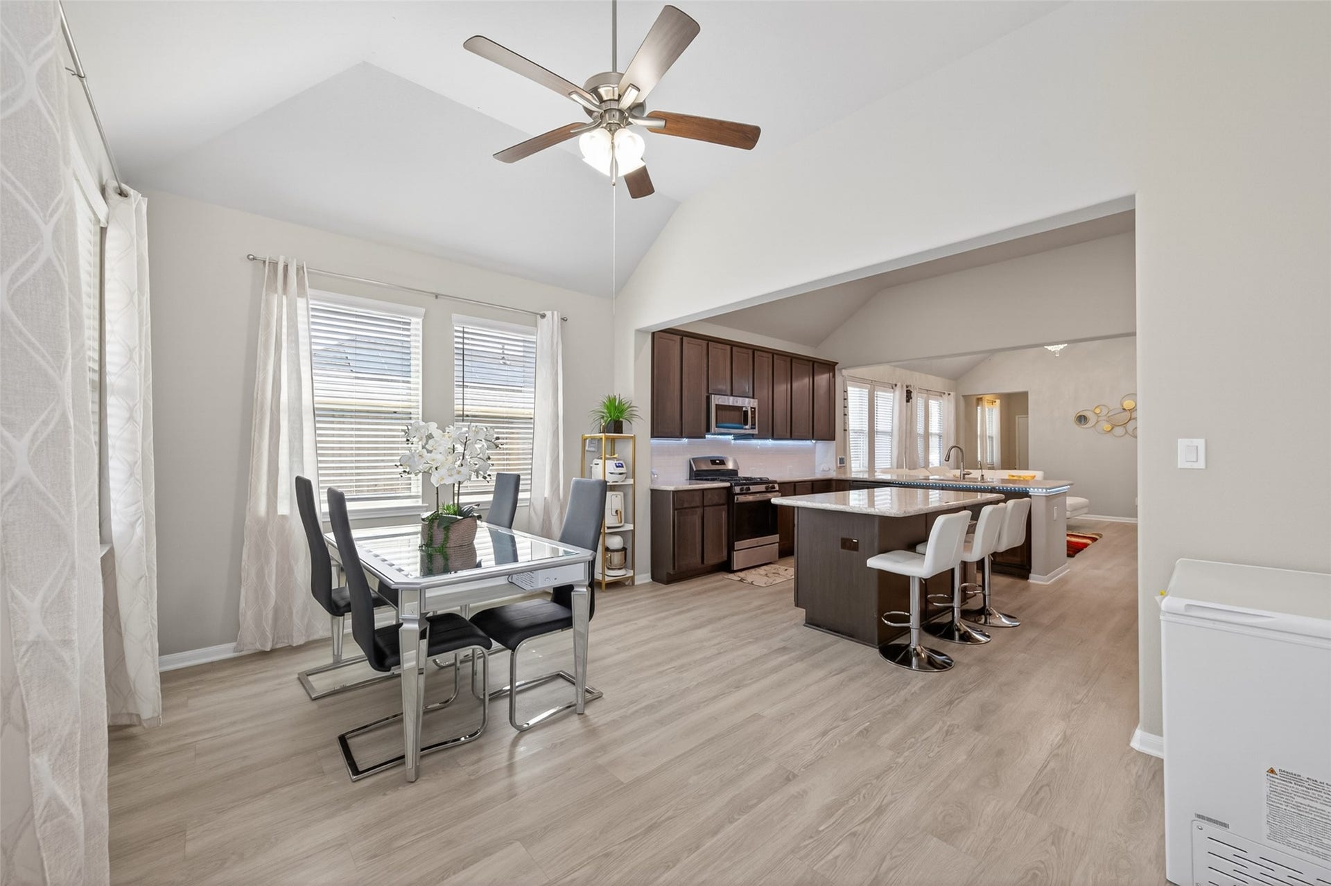 22409 Kinley Street, New Caney, TX 77357 This bright, open-concept dining and kitchen area features a modern design with light wood floors, high ceilings, and ample natural light.