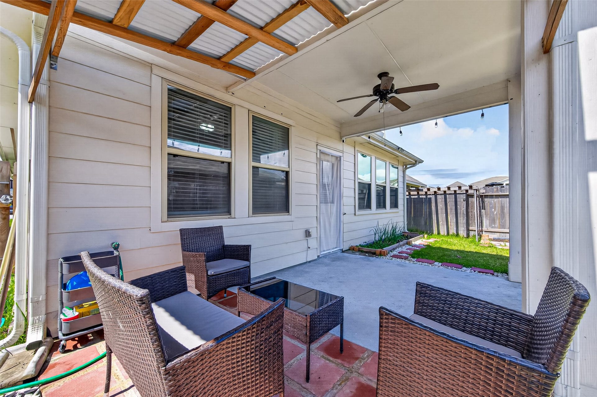 22409 Kinley Street, New Caney, TX 77357 A cozy covered patio with outdoor seating and a ceiling fan, perfect for relaxation.