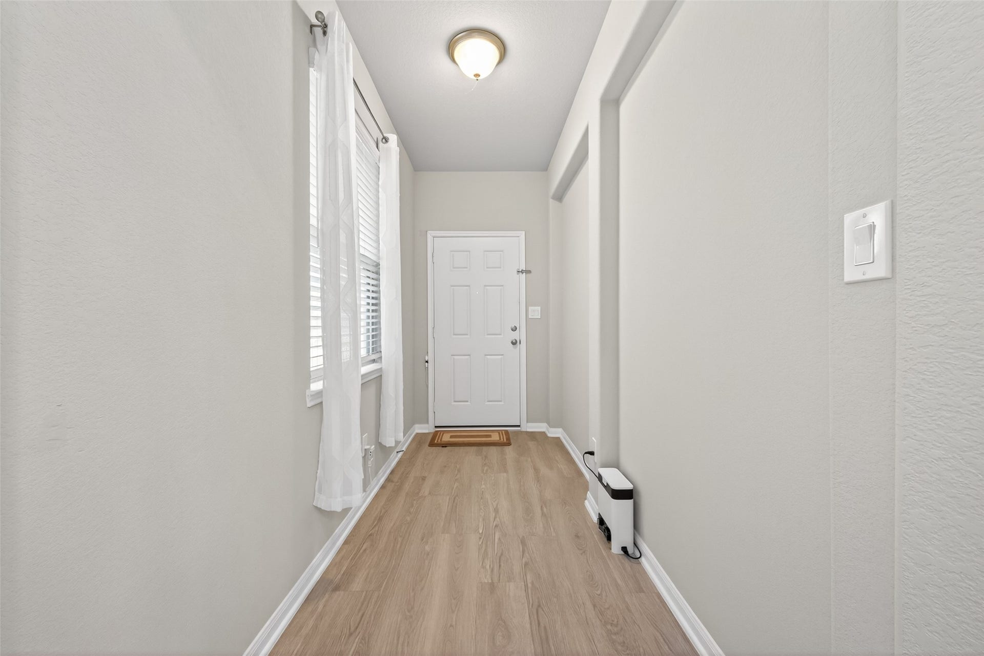 22409 Kinley Street, New Caney, TX 77357 A bright entryway with light wood flooring, neutral walls, and a modern light fixture.