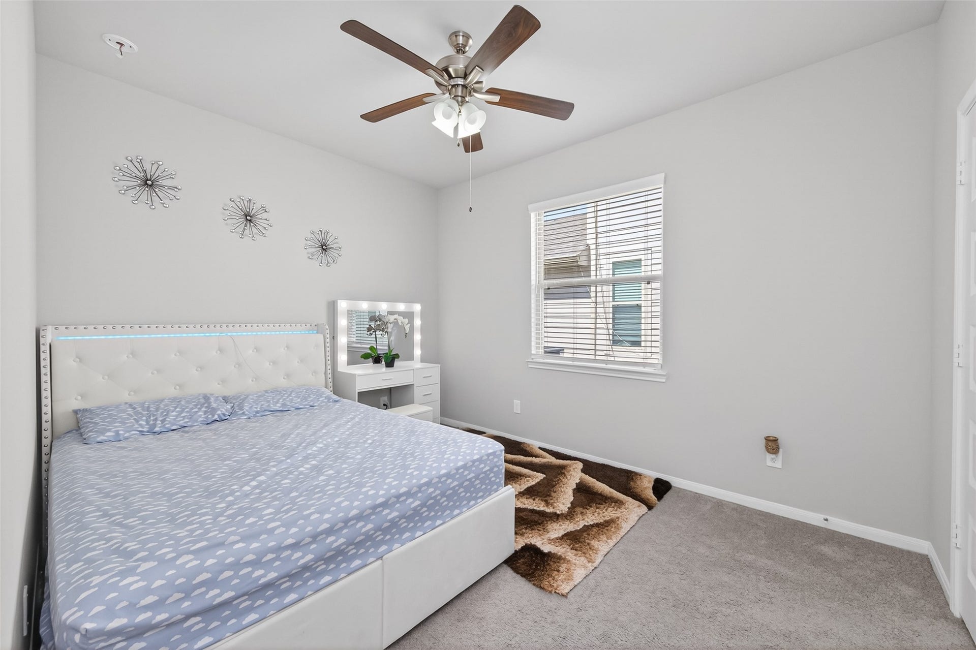 22409 Kinley Street, New Caney, TX 77357 This bedroom features a cozy setup with a modern design. Natural light fills the space from a window, creating a bright and inviting atmosphere.