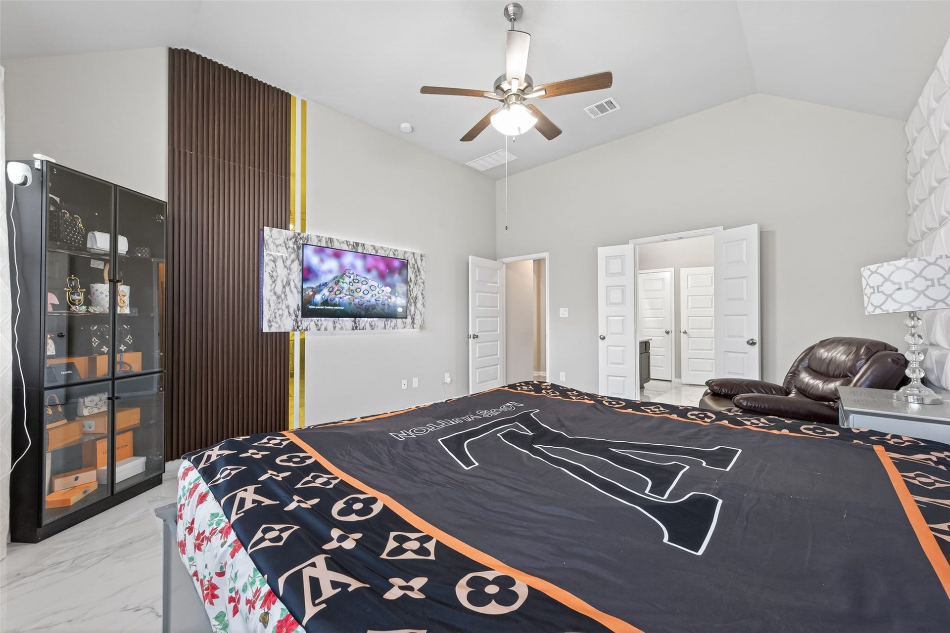 22409 Kinley Street, New Caney, TX 77357 The room has a sleek design with a glass-front cabinet for storage and access to a bathroom through double doors.