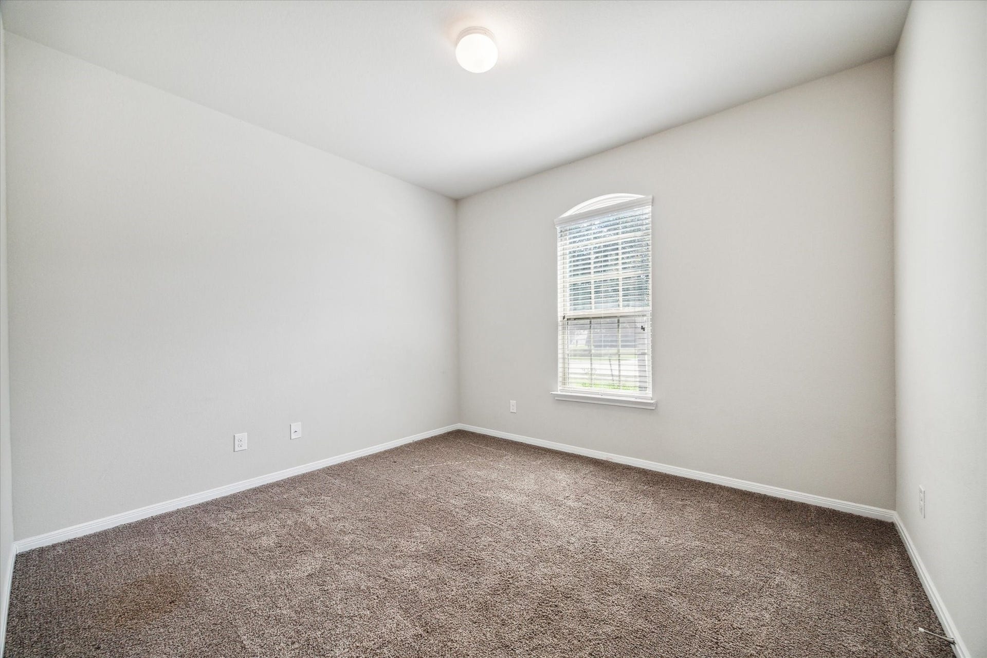 6610 Auburn Terrace Lane, Rosenberg, TX 77471 This is a bright, empty room featuring neutral walls and a textured carpet. It includes a single window with blinds, offering natural light.